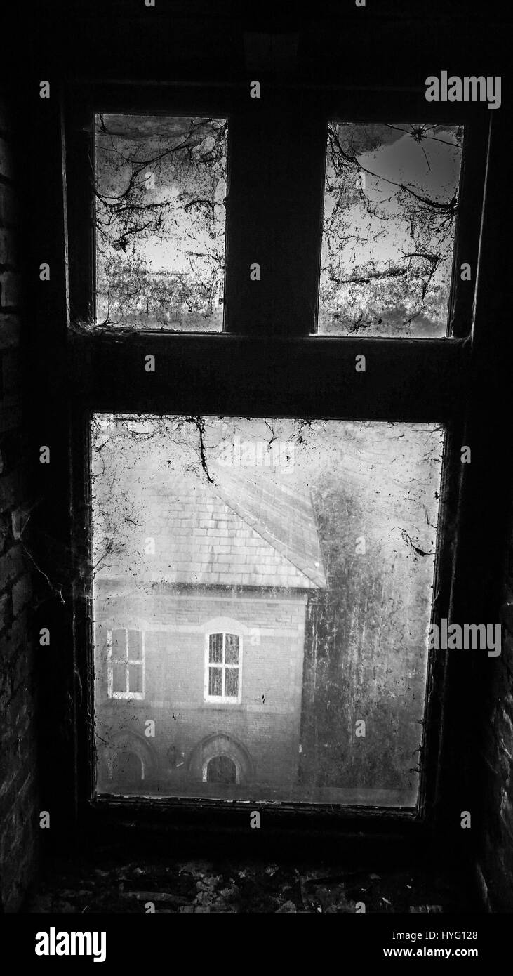 ACCRINGTON Lancashire, Angleterre : Eerie tourné en noir et blanc de la fenêtre couverte de toiles d'araignée. Bienvenue à la ruine qui a été le premier conservateur Club. Une fois célébré pour sa grande salle de bal qui une fois accueilli des parties jusqu'à 1 000 personnes, les images montrent des planches manquantes, les murs et les escaliers, endommagé par un incendie et des actes de vandalisme. À partir de l'extérieur du bâtiment du club conservateur Accrington coupe une étrange figure dans le centre de la ville, près de Blackburn dans le nord-ouest de l'Angleterre. Une publication locale sous le nom de James Cole (pas son vrai nom) a eu la chance de Banque D'Images