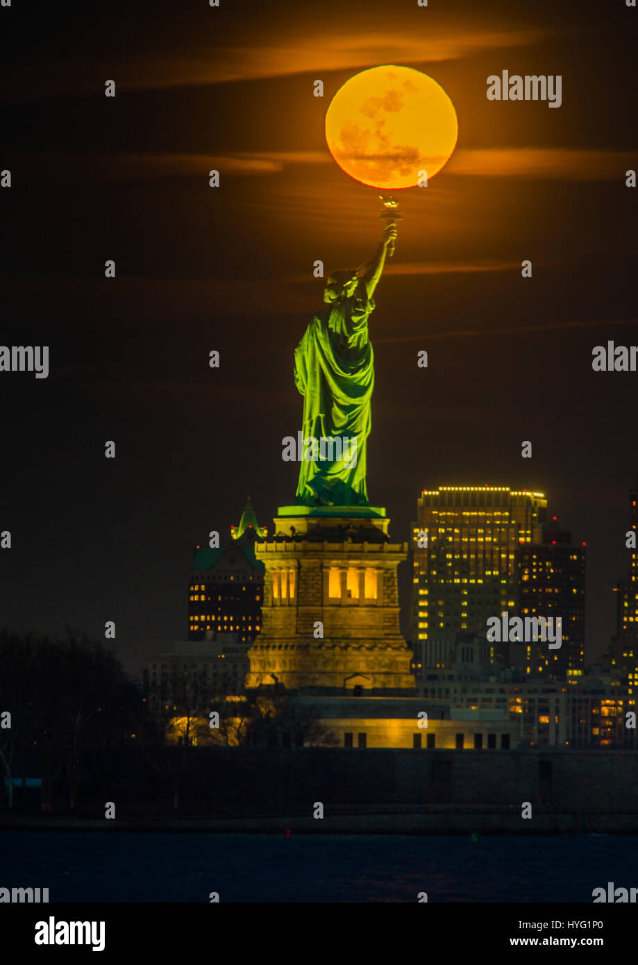 NEW YORK, USA : pris entre la lune et la ville de New York la statue de la liberté semble avoir son flambeau allumé avec une boule de lumière orange. Des images incroyables, montrer la pleine lune de sang de monter jusqu'à l'emblématique dame verte, illuminant la ville ci-dessous dans des tons orange. D'autres photos montrent l'Empire State Building est éclairé par l'arrière ce spectaculaire disque céleste. Rédacteur technique américaine Jennifer Khordi (46) a été en mesure de saisir ces photos à couper le souffle de l'horizon de Jersey City et Kearny ville dans le New Jersey. Banque D'Images