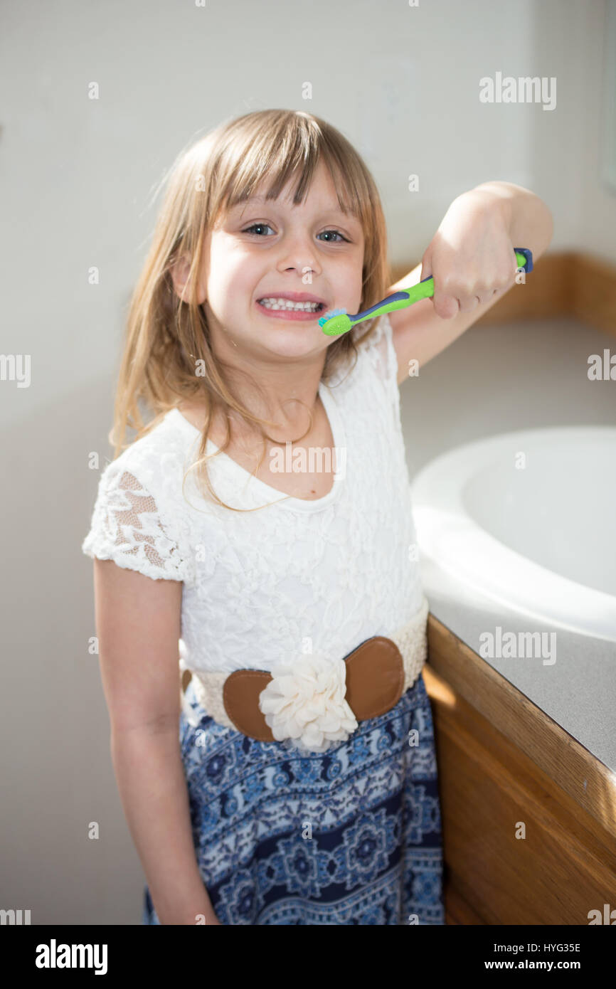 Une petite fille dans la salle de bain se brosser les dents. Banque D'Images