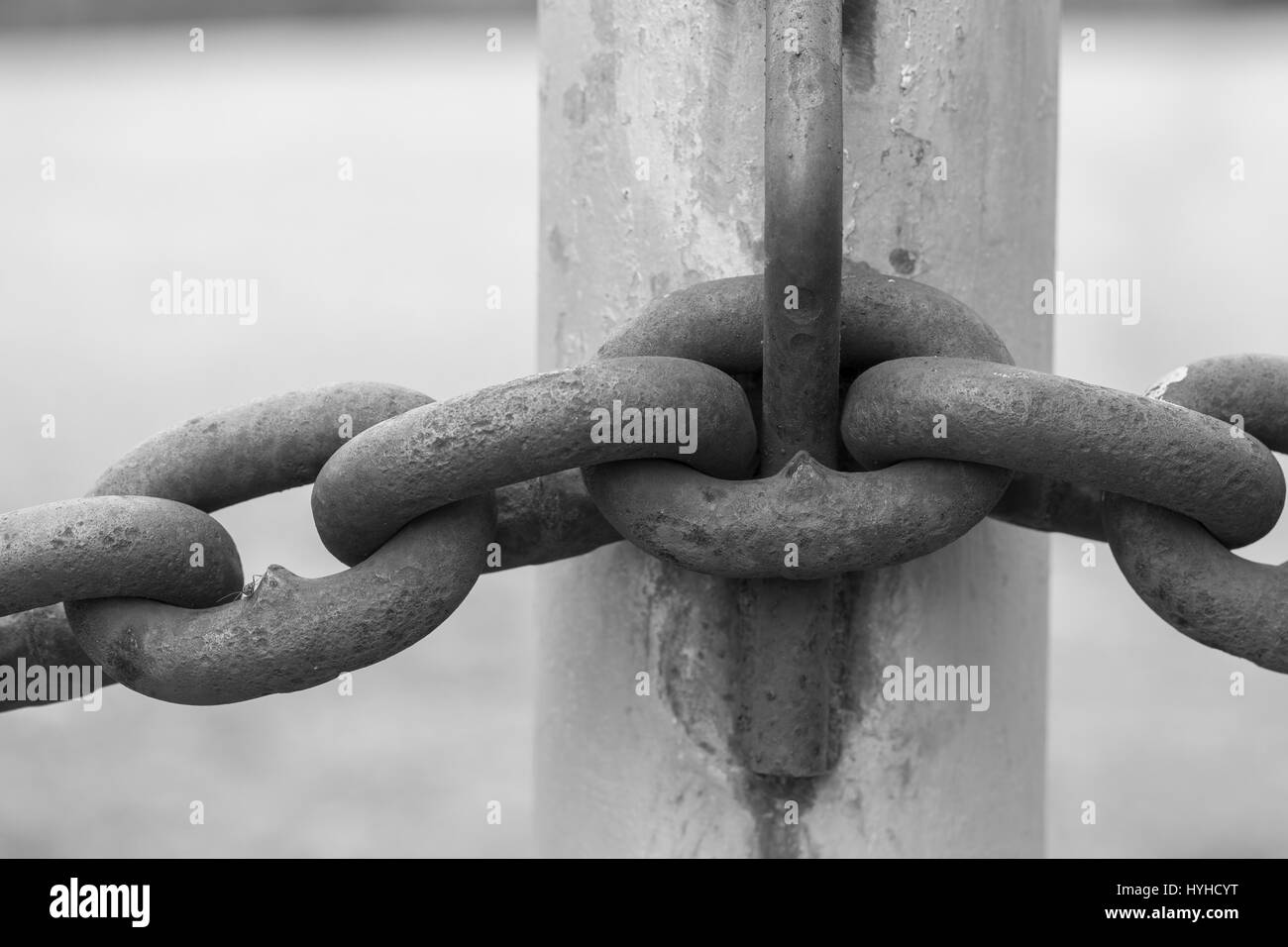 Un gros plan B&W image abstraite d'une clôture à mailles de chaîne rouillée. Banque D'Images