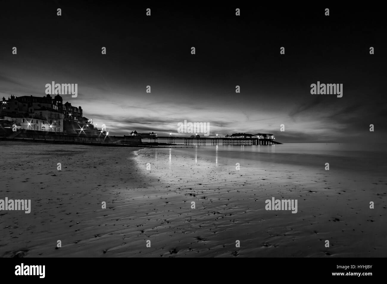 Voir la soirée de jetée de Cromer et plage de Norfolk après le coucher du soleil photographié en noir et blanc Banque D'Images