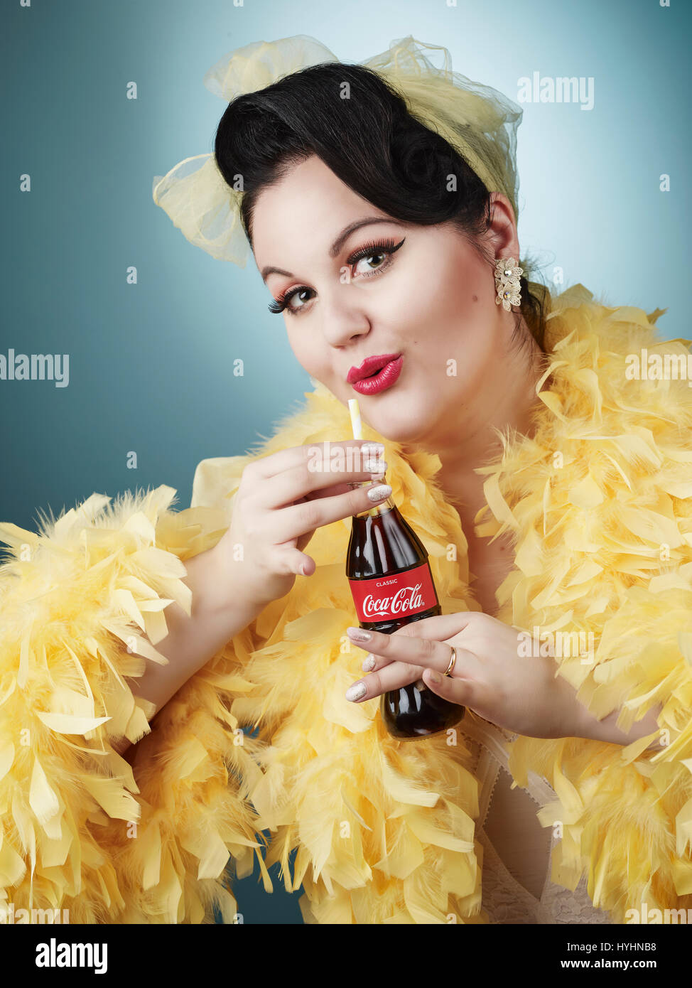 Pin-up femme portant feather nuisette et elle tenant une bouteille de Coca Cola Banque D'Images