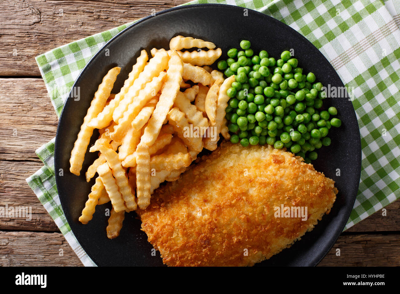 Fish and chips avec les pois verts close-up sur une plaque sur une table horizontale vue du dessus. Banque D'Images