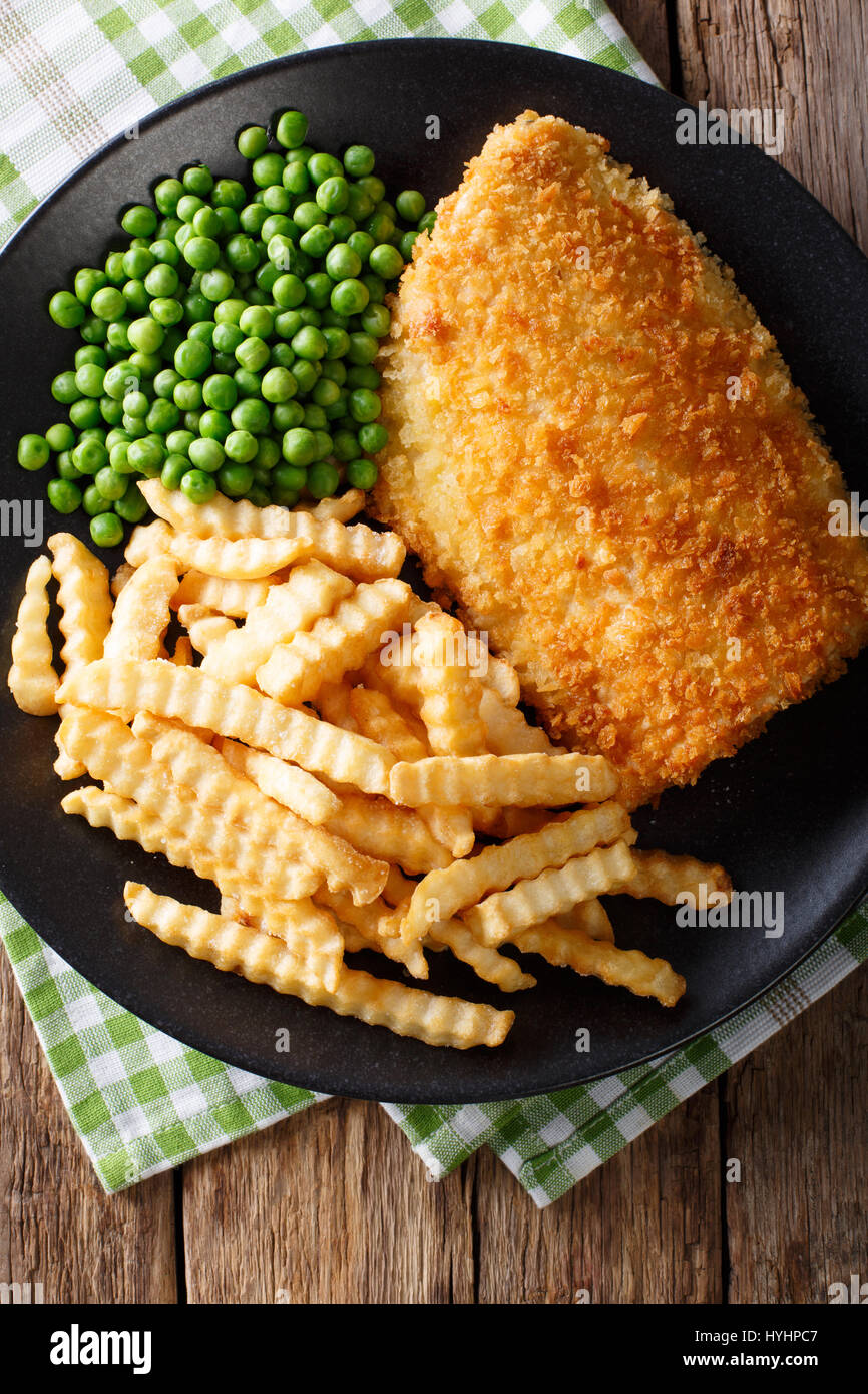 La morue délicieux fish and chips avec pois gros plan sur une assiette sur la table. Vue verticale d'en haut Banque D'Images