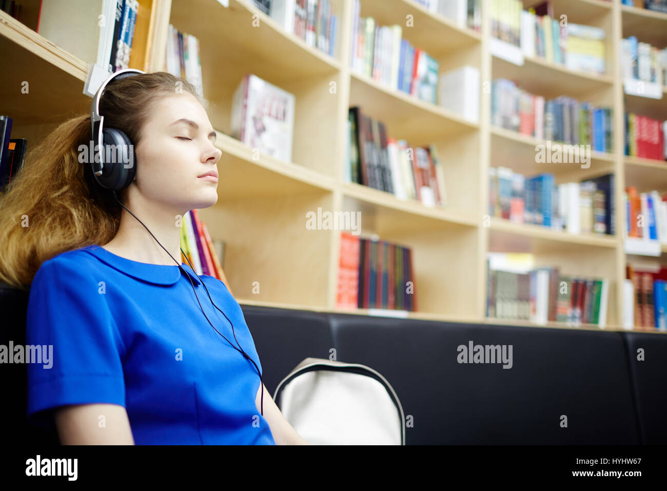 Belle fille à écouter un livre audio Banque D'Images