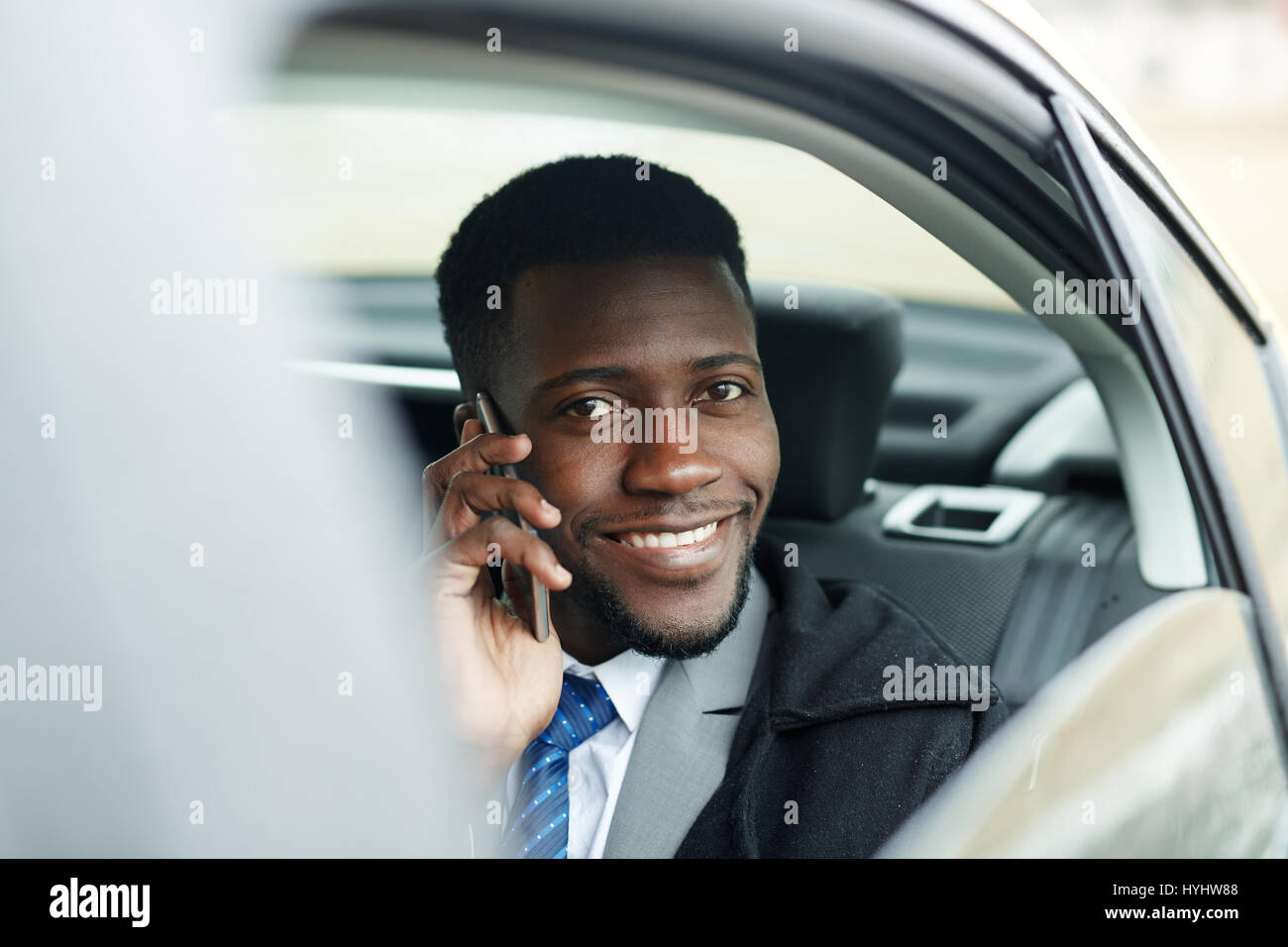 Succès African Businessman parlant au téléphone en voiture Banque D'Images