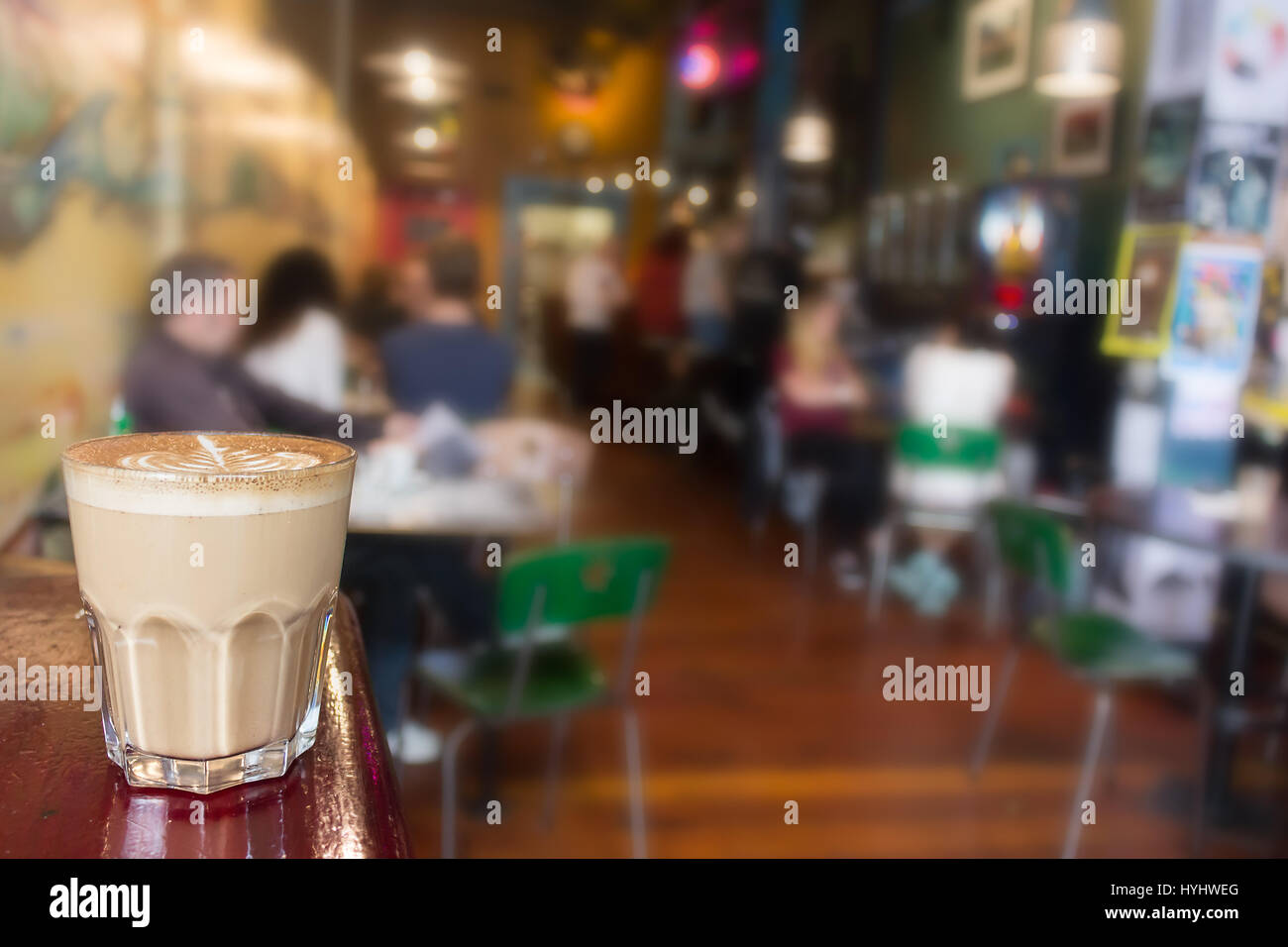 Un cappuccino sur sur un gros plan de verre, de l'intérieur les gens fond flou. Banque D'Images