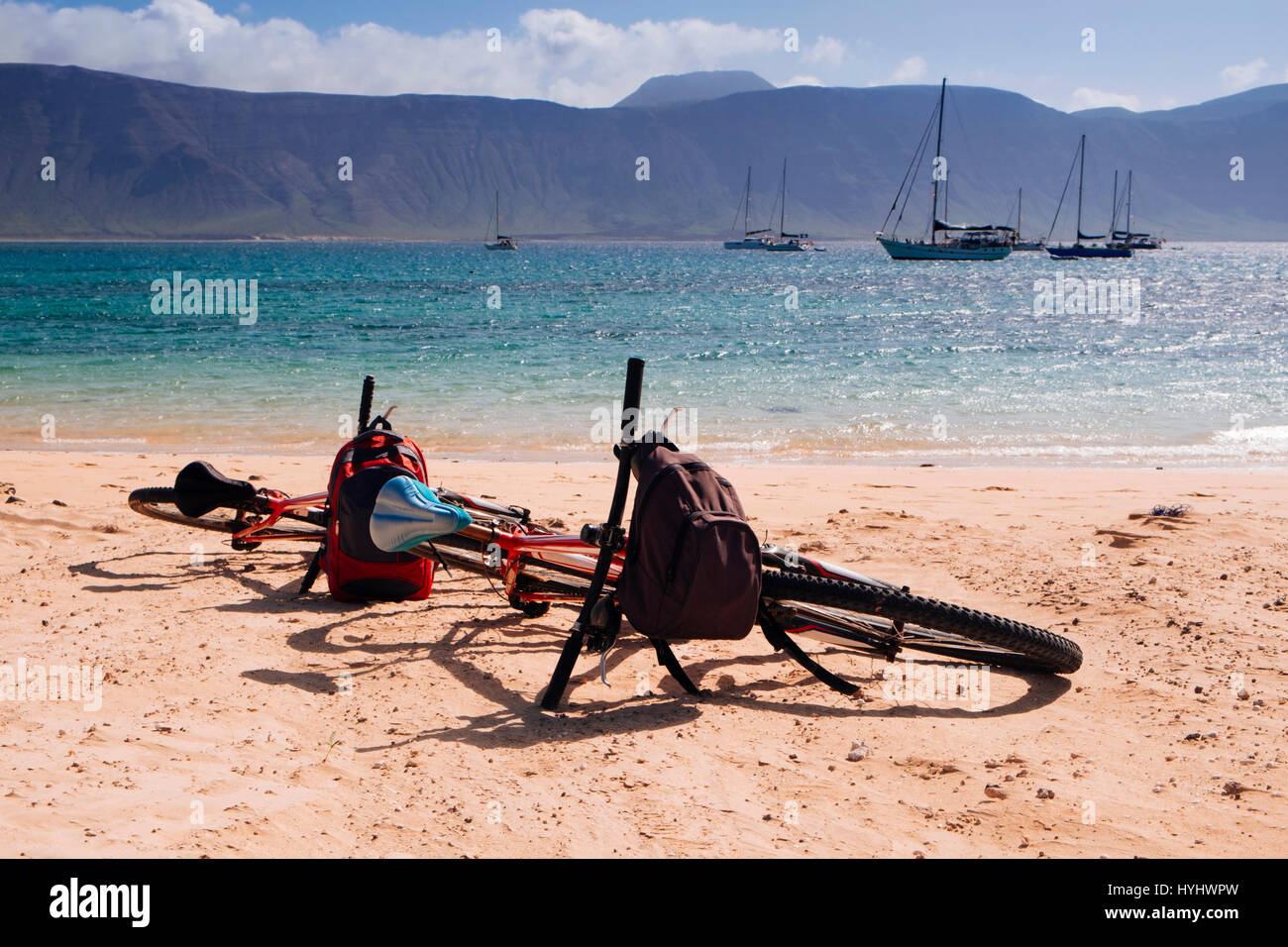 Une paire de bicyclettes sur le sable blanc de la plage de La Francesa en La Graciosa island, dans les îles Canaries, Espagne, avec le massif de Famara Lanzarote isl Banque D'Images