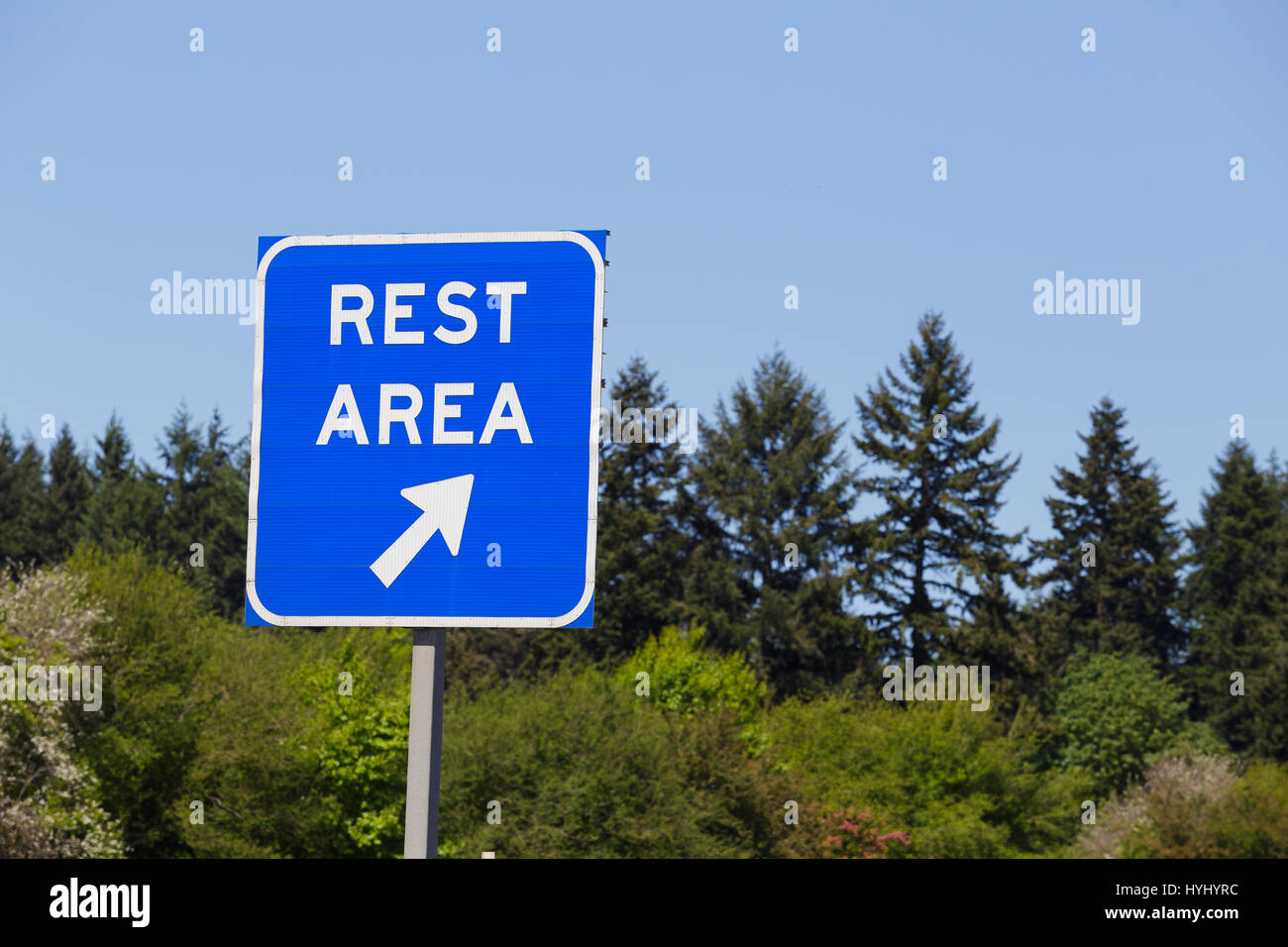 Aire de repos Bleu signe pointe vers une sortie de l'autoroute où les conducteurs peuvent se détendre et se reposer pendant leur voyage. Banque D'Images