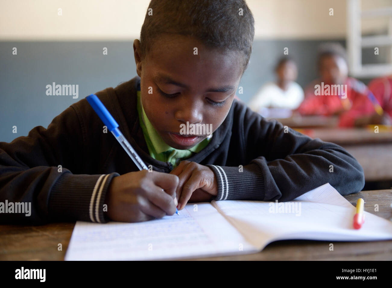 Garçon, étudiant l'écriture, 12 ans, école primaire, Fianarantsoa, Madagascar Banque D'Images