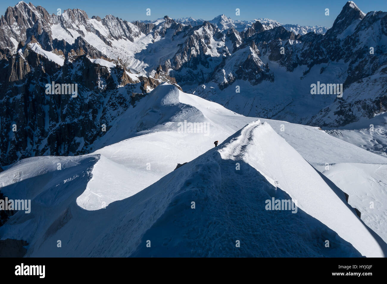 Climber ascending dernière ligne droite sur l'arete ridge menant à Aiguille du Midi au début de l'hiver ensoleillé Banque D'Images