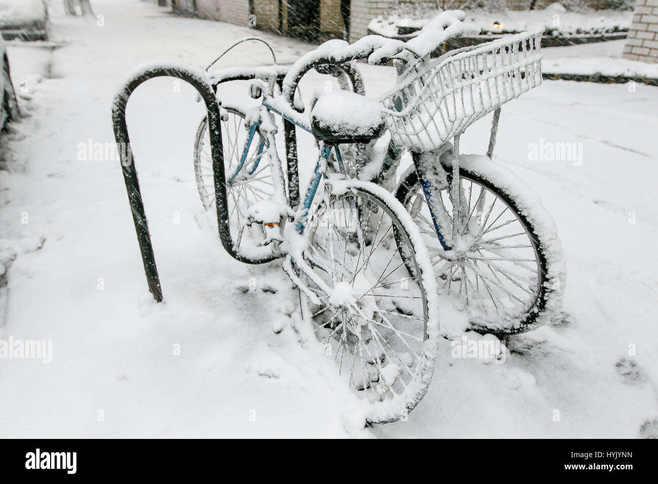 Deux bicyles enchaînés à un rack à l'extérieur sont couvertes de neige pendant une chute de neige à Manhattan. Banque D'Images