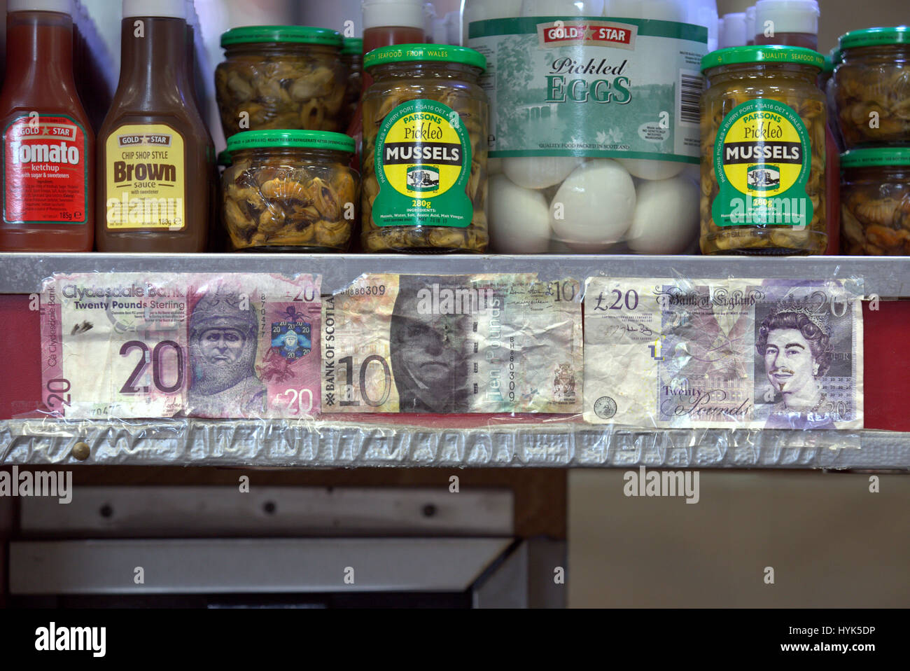 Faux billets de monnaie épinglé à un jusqu'au-dessus dans un plateau de poisson et frites à emporter boutique Banque D'Images