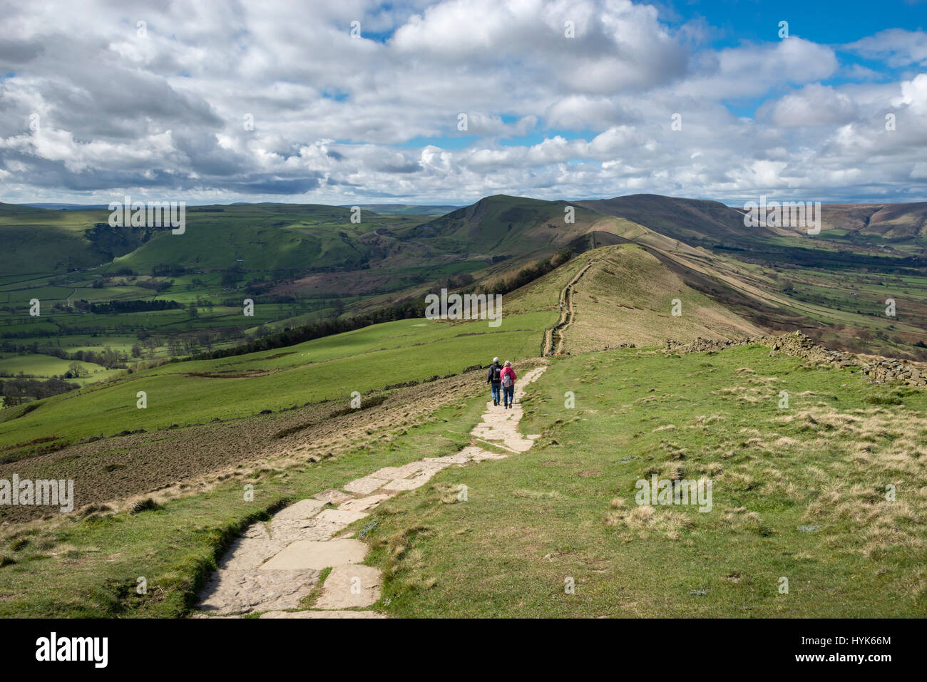 Couple walking la crête à pied de perdre Hill à Mam Tor dans le parc national de Peak District, Derbyshire, Angleterre. Banque D'Images