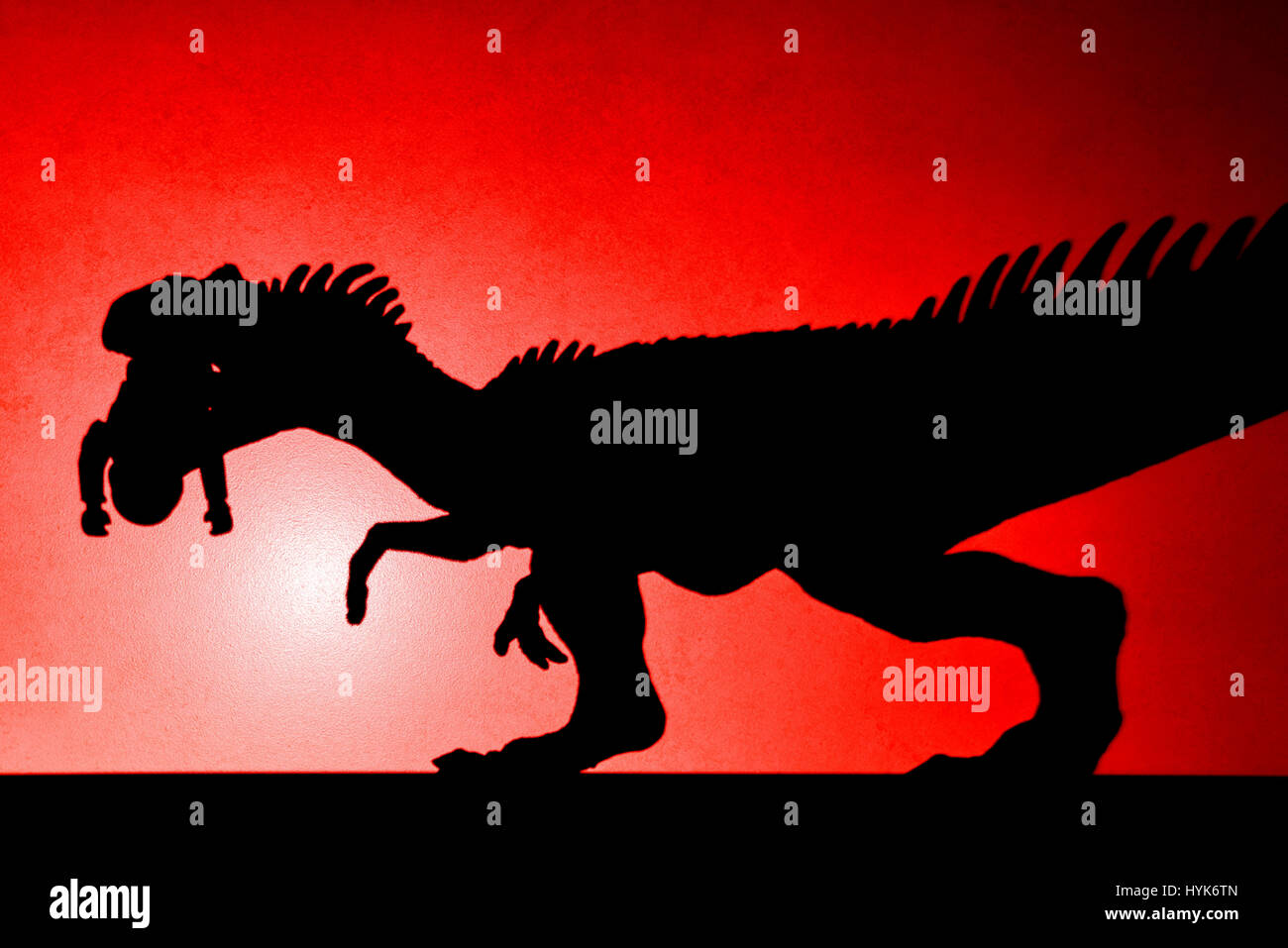 Tache rouge ombre légère de l'Allosaurus de mordre un corps sur mur pas un logo ou d'une marque Banque D'Images