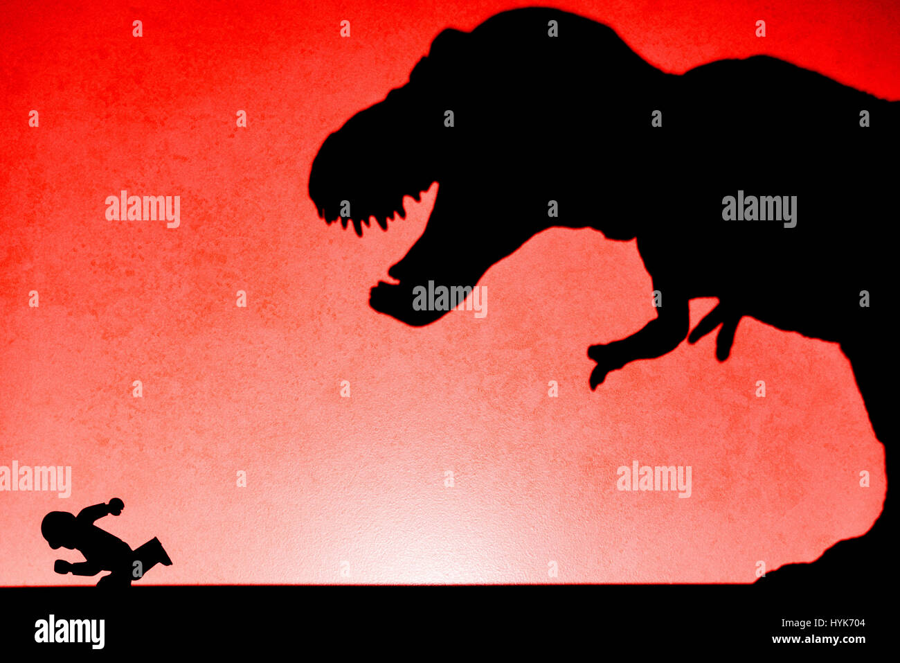 Ombre de tyrannosaurus chasing humain sur mur pas un logo ou d'une marque Banque D'Images