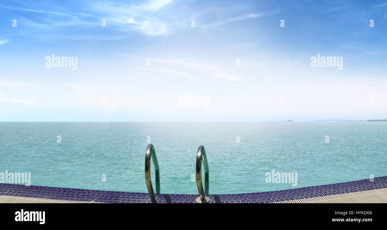 Piscine à débordement face à la mer au lever du soleil Banque D'Images