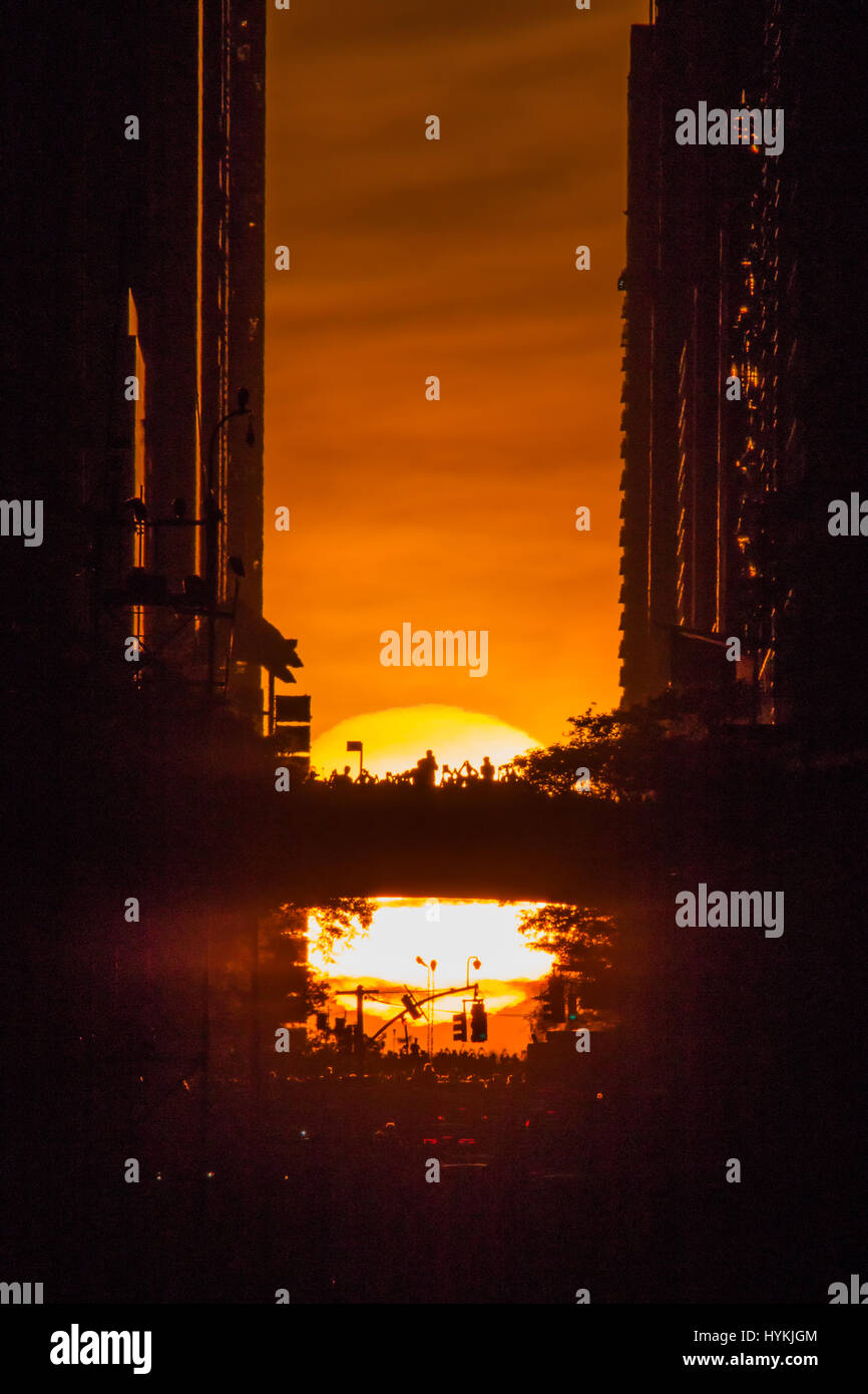 La ville de New York, USA : UN HOMMAGE À la légendaire de l'Angleterre Stonehenge gatherings New-yorkais se pressent à témoin au soleil, il trouve sur le dernier "Manhattanhenge" de 2016. Les images montrent comment les amoureux du soleil s'est agréablement surpris que le soleil descendait lentement entre les tours de la 42e Rue - connu des New-yorkais comme le cœur même de leur ville. Cet événement se produit solaire seulement deux fois par année, lorsque le soleil est à l'ouest des coupes à travers exactement les rues de Manhattan. Le dernier a été vu le 28 mai de cette année. NYC photographe Peter Alessandria décrit la scène. Banque D'Images