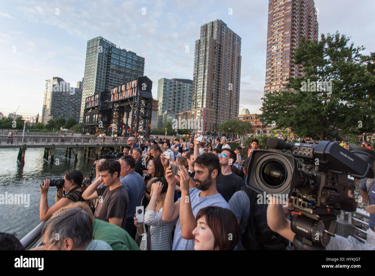 La ville de New York, USA : UN HOMMAGE À la légendaire de l'Angleterre Stonehenge gatherings New-yorkais se pressent à témoin au soleil, il trouve sur le dernier "Manhattanhenge" de 2016. Les images montrent comment les amoureux du soleil s'est agréablement surpris que le soleil descendait lentement entre les tours de la 42e Rue - connu des New-yorkais comme le cœur même de leur ville. Cet événement se produit solaire seulement deux fois par année, lorsque le soleil est à l'ouest des coupes à travers exactement les rues de Manhattan. Le dernier a été vu le 28 mai de cette année. NYC photographe Peter Alessandria décrit la scène. Banque D'Images