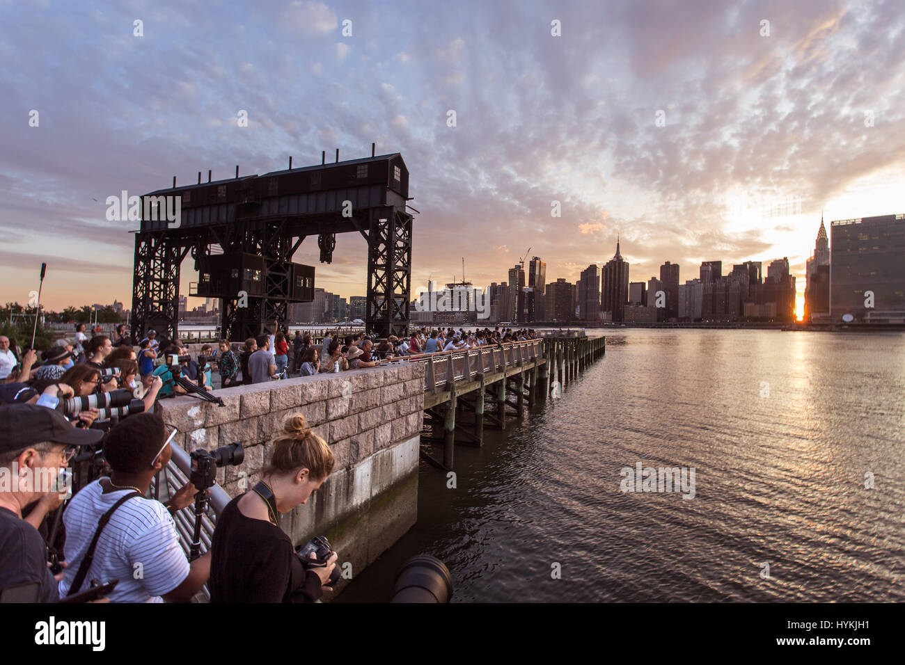 La ville de New York, USA : UN HOMMAGE À la légendaire de l'Angleterre Stonehenge gatherings New-yorkais se pressent à témoin au soleil, il trouve sur le dernier "Manhattanhenge" de 2016. Les images montrent comment les amoureux du soleil s'est agréablement surpris que le soleil descendait lentement entre les tours de la 42e Rue - connu des New-yorkais comme le cœur même de leur ville. Cet événement se produit solaire seulement deux fois par année, lorsque le soleil est à l'ouest des coupes à travers exactement les rues de Manhattan. Le dernier a été vu le 28 mai de cette année. NYC photographe Peter Alessandria décrit la scène. Banque D'Images