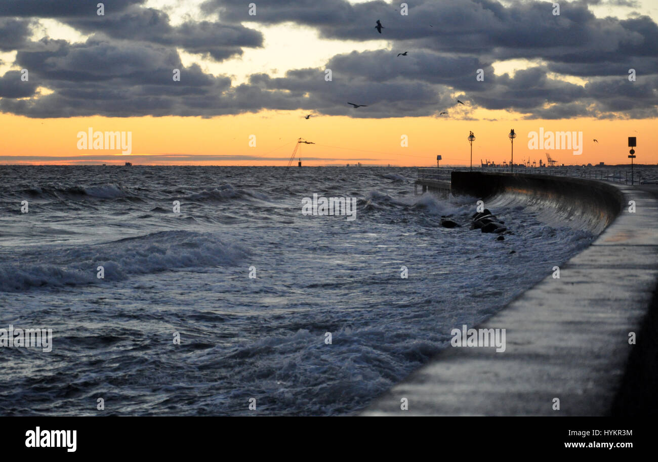 Nuageux orageux le lever du soleil sur la mer baltique en Pologne avec pier et les mouettes voir Banque D'Images