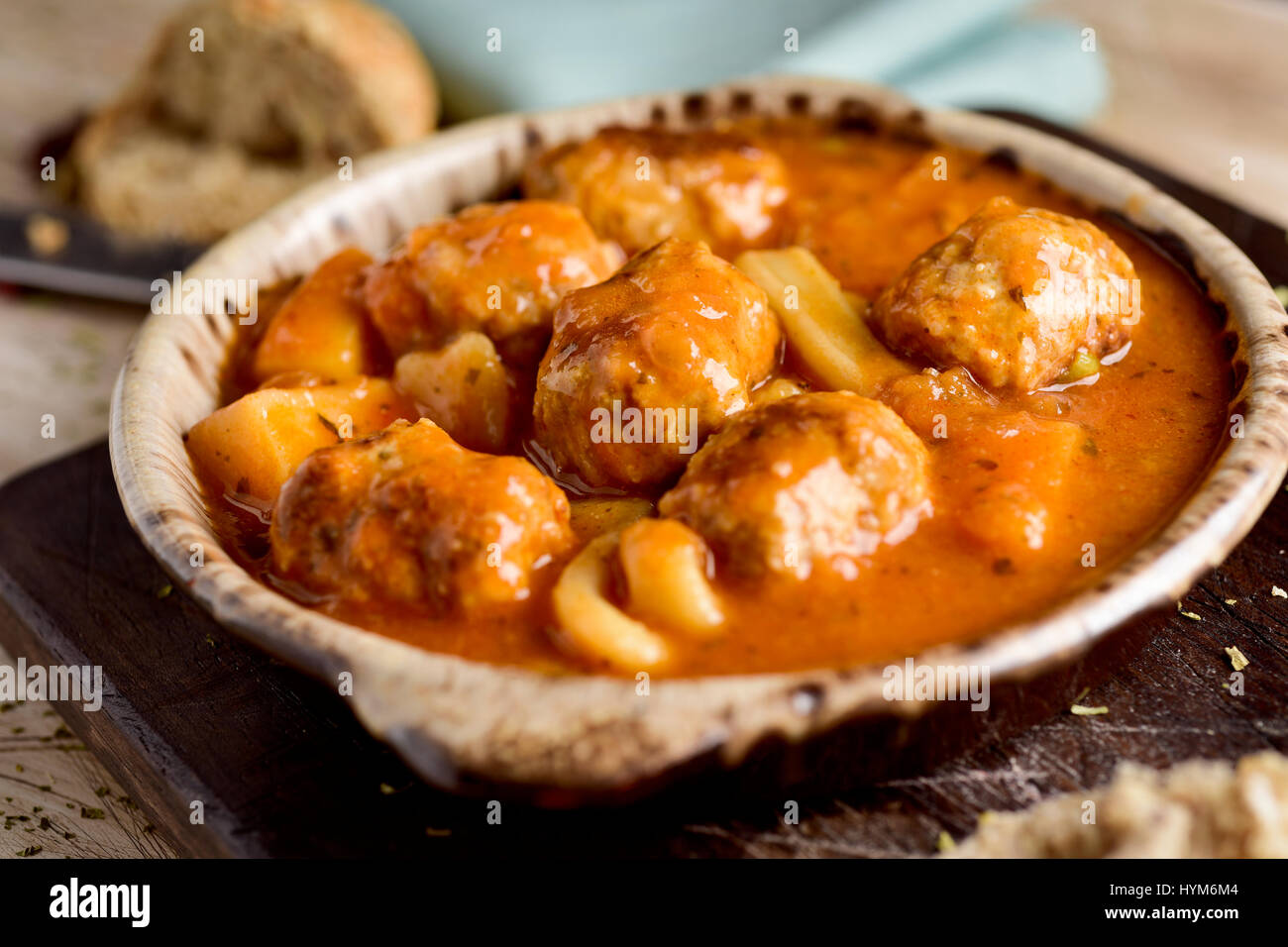 Libre d'un bol en terre cuite typique espagnole avec albondigas con sepia, boulettes de seiche, sur une table en bois rustique Banque D'Images