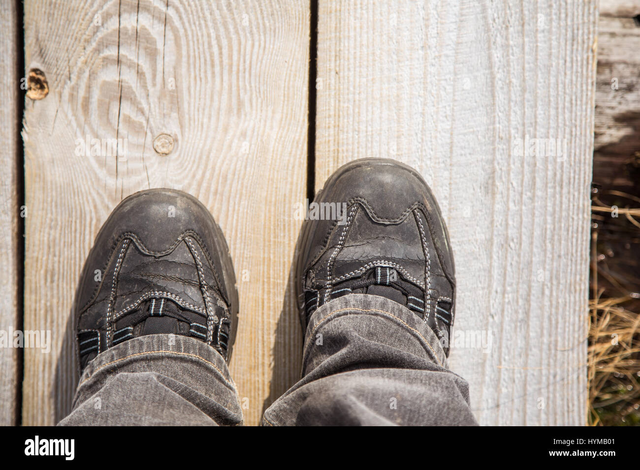 Deux pieds sur un sentier en bois au cours de la randonnée dans un printemps précoce. Banque D'Images