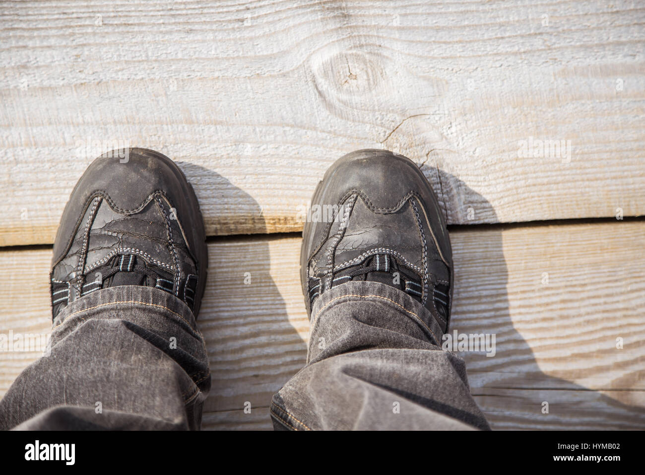 Deux pieds sur un sentier en bois au cours de la randonnée dans un printemps précoce. Banque D'Images