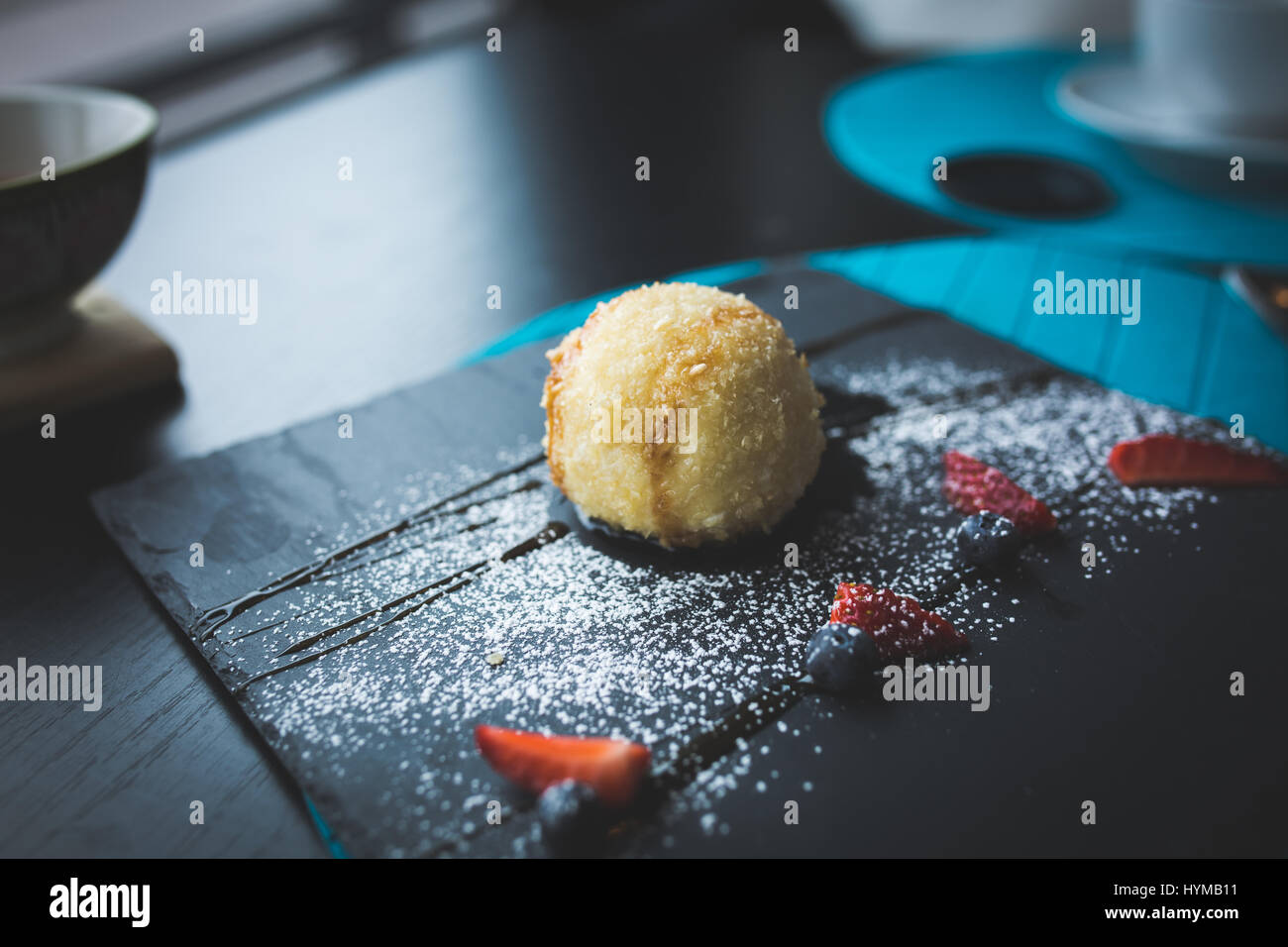 Grillades de la glace dans la noix de coco avec sauce sur la plaque en pierre noire. Arrière-plan de l'alimentation asiatique. Concept de l'alimentation. Le restaurant place avec table en bois. Copie espace fo Banque D'Images