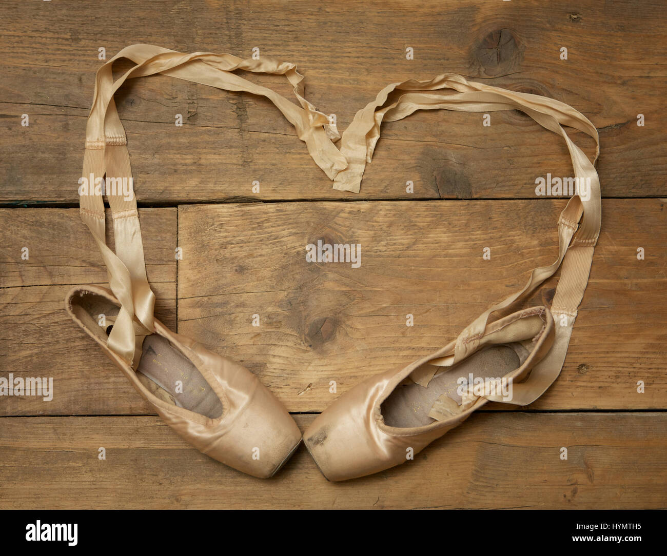 Paire de chaussures de ballet sur plancher en bois avec ruban en forme de coeur - voir ci-dessus Banque D'Images
