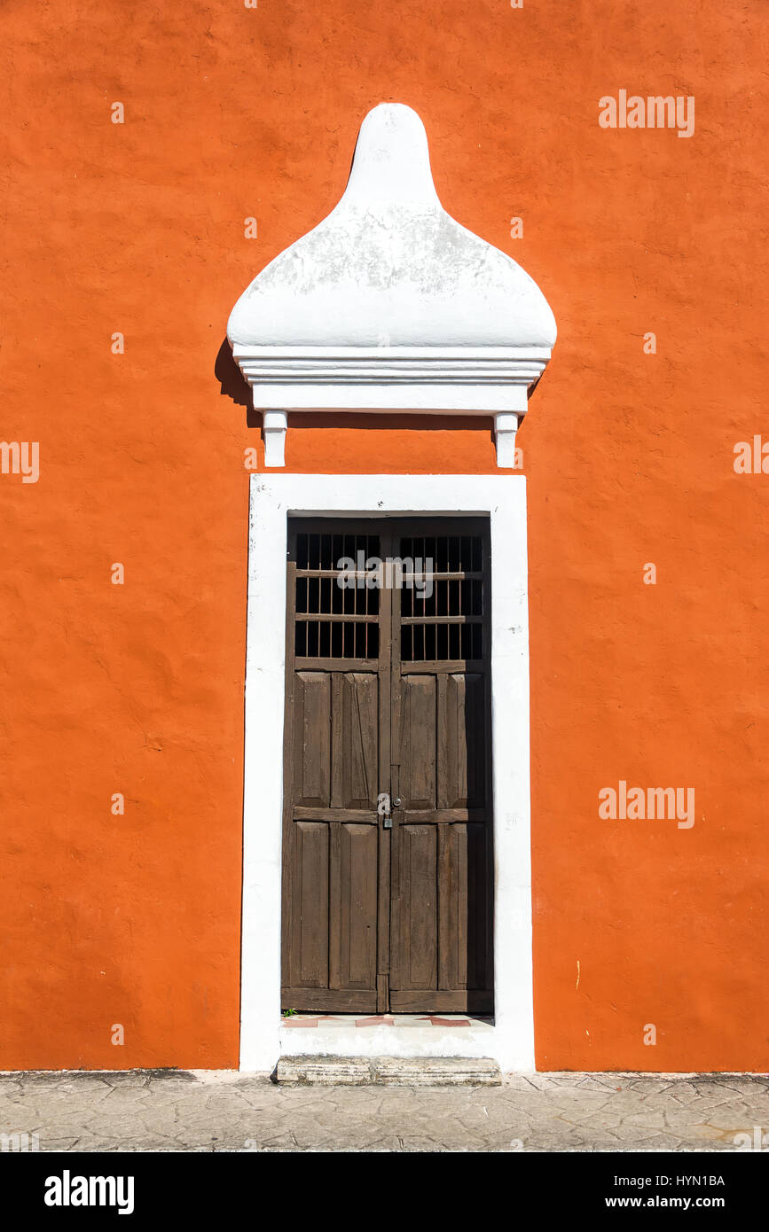 Vieille porte en bois sur une orange édifice colonial dans le centre historique de Valladolid, Mexique Banque D'Images