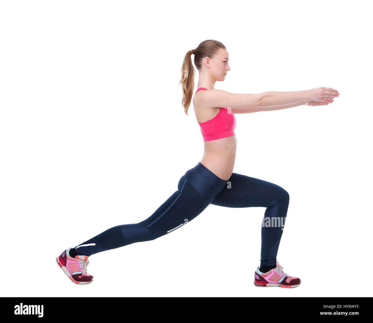 Side view portrait of a young woman stretching des muscles des jambes avant l'exercice d'entraînement sur fond blanc isolé Banque D'Images