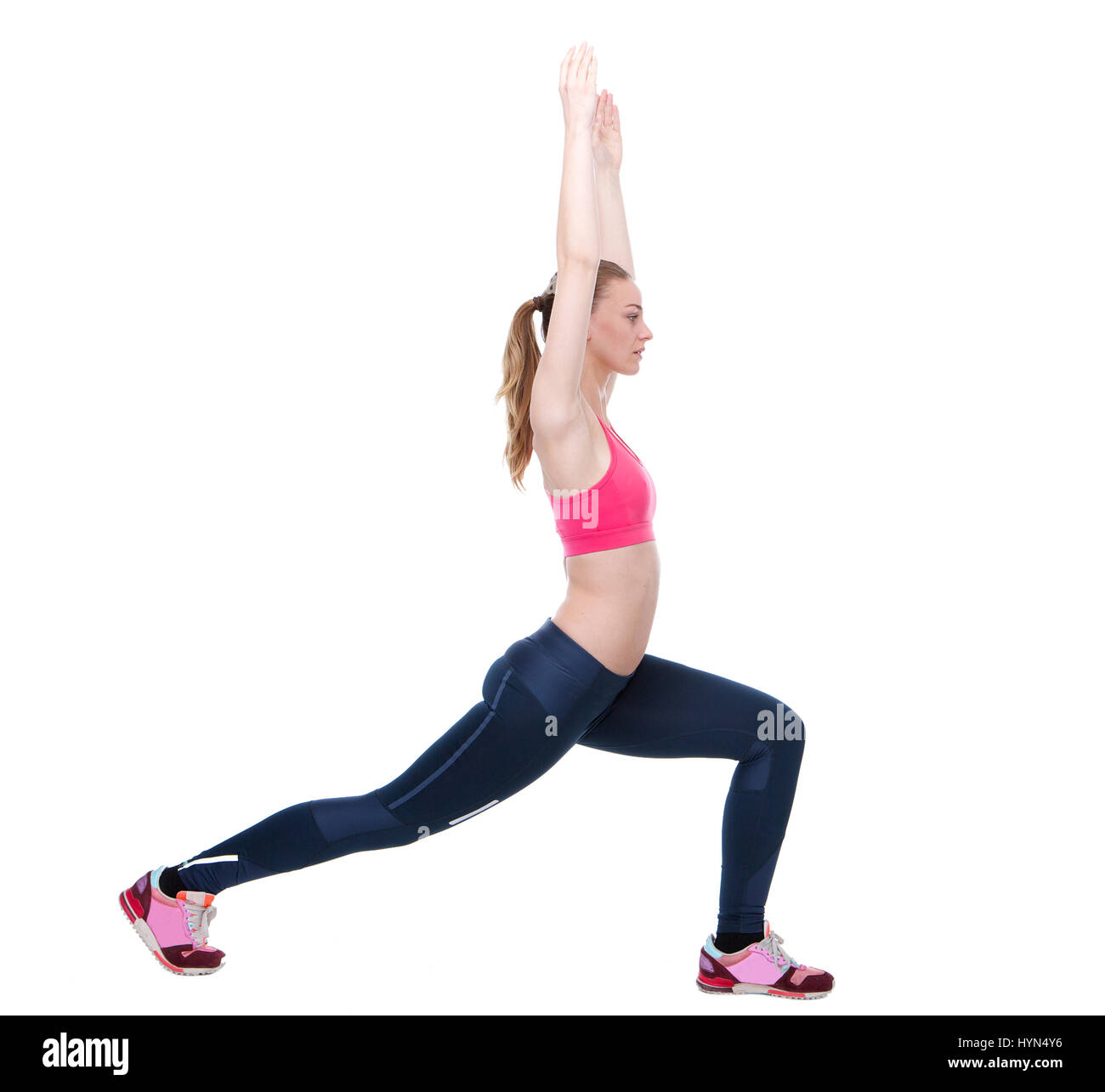 Side view portrait of a young woman doing exercise s'étendant sur un fond blanc Banque D'Images