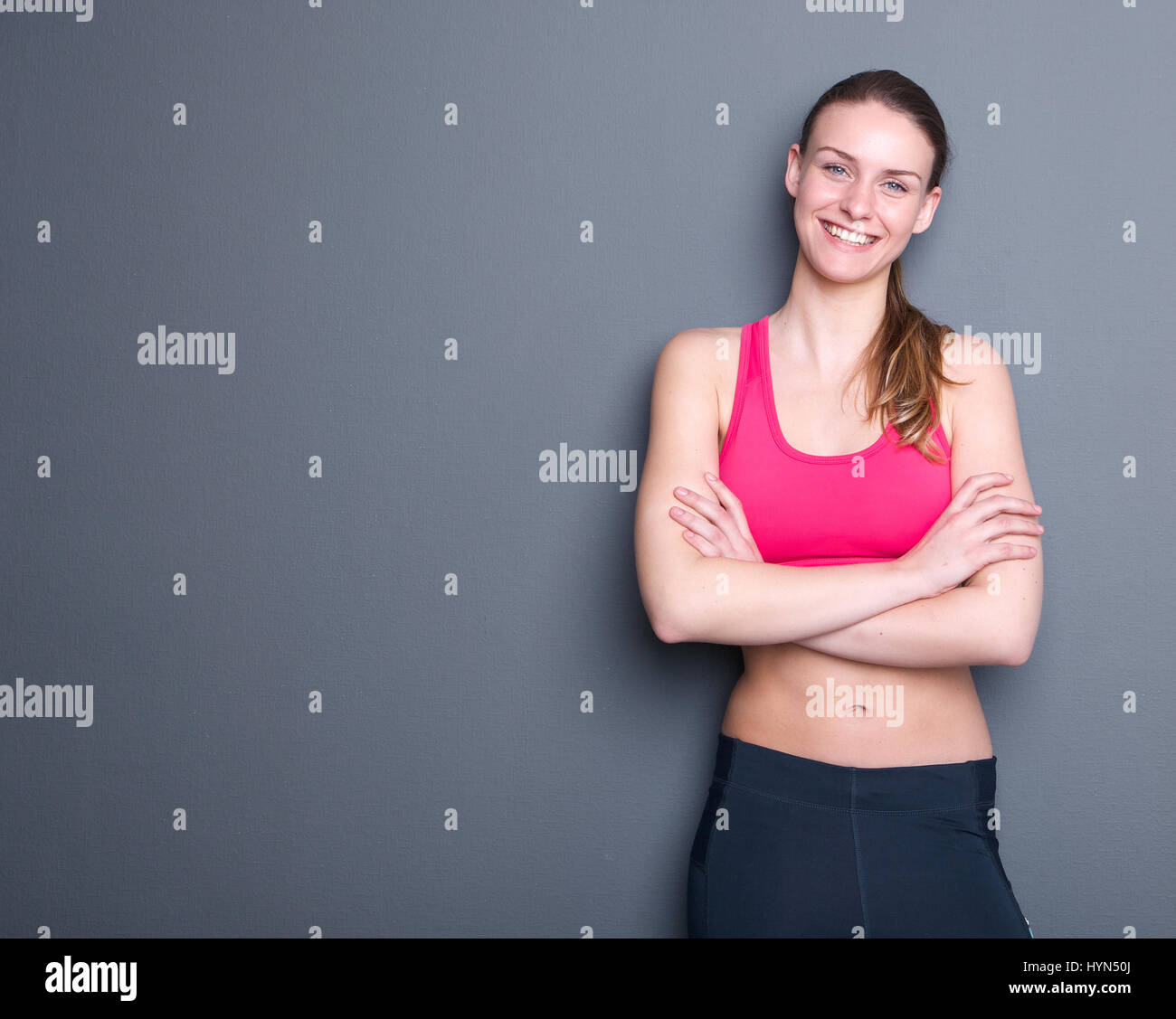 Portrait d'une belle jeune femme sport smiling sur fond gris Banque D'Images