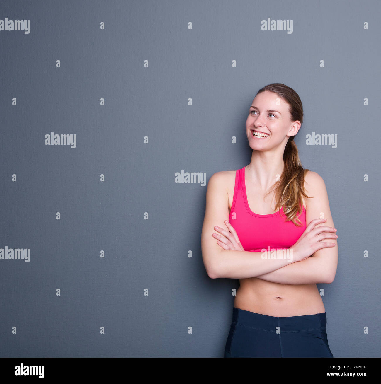 Portrait d'une jolie jeune femme sportive smiling, portrait sur fond gris Banque D'Images