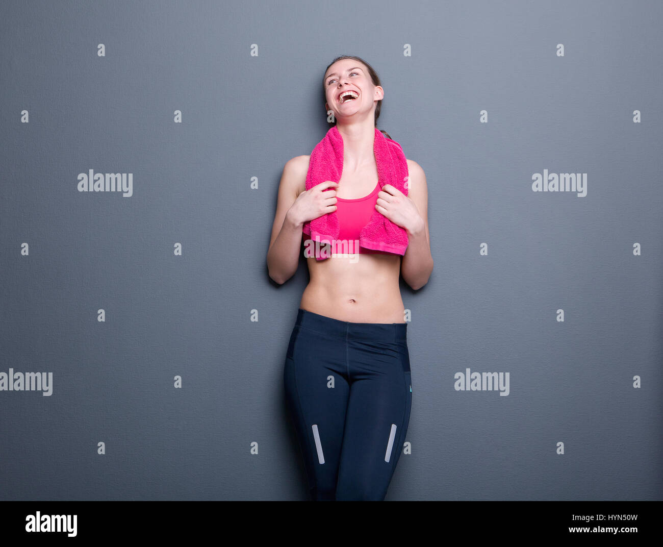 Portrait d'une jeune femme en riant de sport sur fond gris Banque D'Images