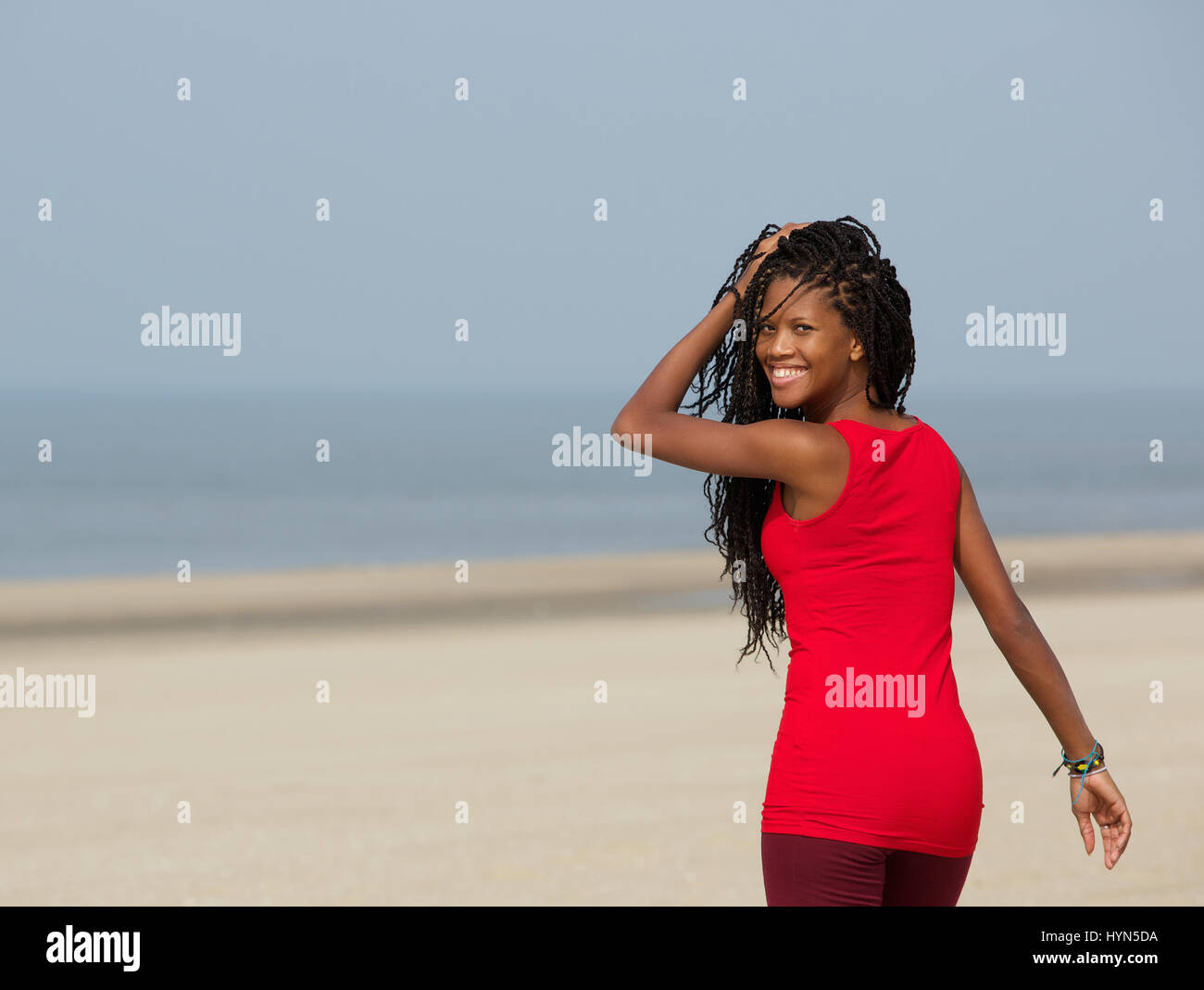 Close up portrait of a beautiful young african american woman smiling, marcher sur la plage Banque D'Images