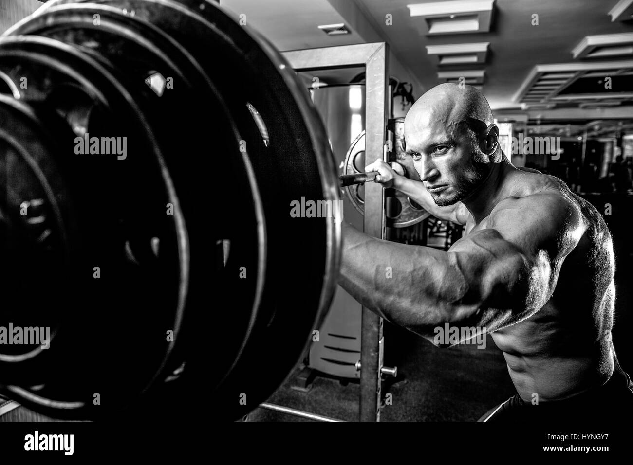 Bodybuilder chauve préparait pour l'exercice d'haltères avec in gym Banque D'Images