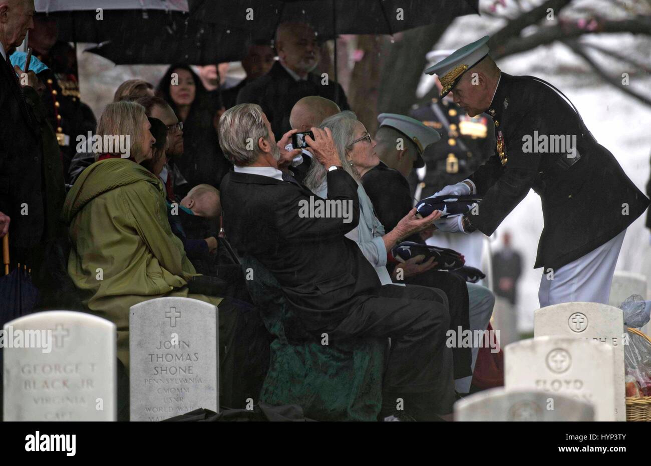 Arlington, Virginia, USA. 6ème apr 2017. Commandant de la Marine Corps le général Robert Neller, droite, présente le drapeau américain à Carolyn Glenn, fille de John Glenn, au cours de la service de la section 35 du Cimetière National d'Arlington, le 6 avril 2017 à Arlington, en Virginie. Glenn, le premier astronaute américain en orbite autour de la Terre et plus tard un sénateur des Etats-Unis, est décédé à l'âge de 95 ans le 8 décembre 2016. Credit : Planetpix/Alamy Live News Banque D'Images