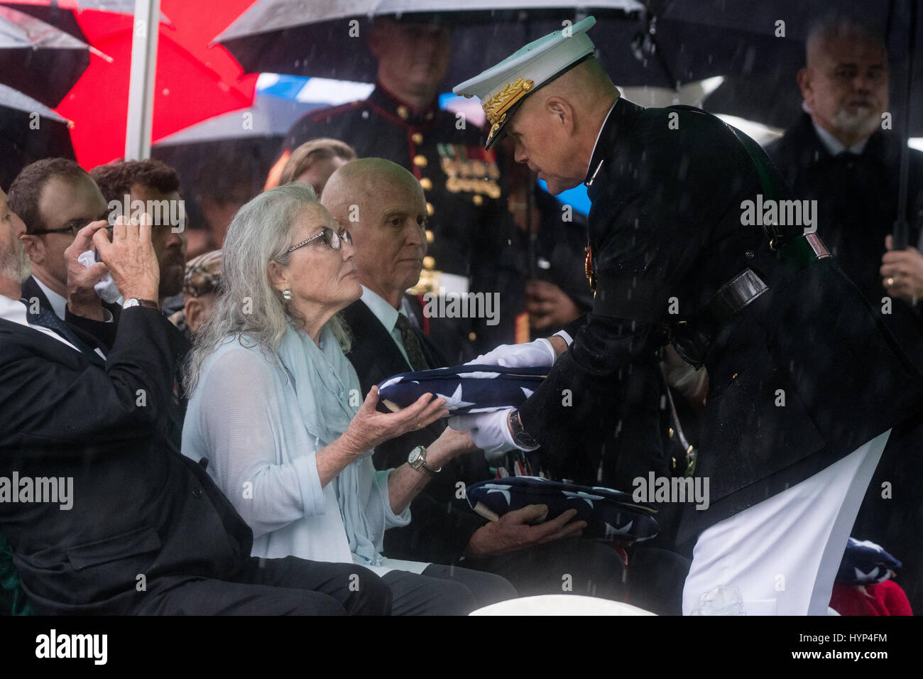 Arlington, États-Unis d'Amérique. 06 avr, 2017. Commandant de la Marine Corps le général Robert Neller, droite, présente le drapeau américain à Carolyn Glenn, fille de John Glenn, au cours de la service de la section 35 du Cimetière National d'Arlington, le 6 avril 2017 à Arlington, en Virginie. Glenn, le premier astronaute américain en orbite autour de la Terre et plus tard un sénateur des Etats-Unis, est décédé à l'âge de 95 ans le 8 décembre 2016. Credit : Planetpix/Alamy Live News Banque D'Images