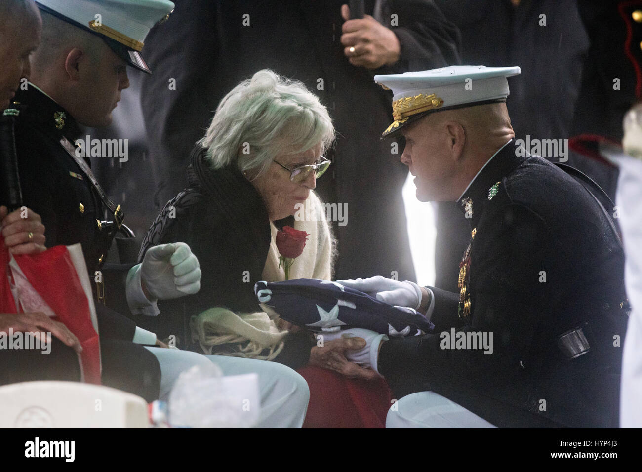 Arlington, États-Unis d'Amérique. 06 avr, 2017. Commandant de la Marine Corps le général Robert Neller, droite, le remet à Anne Glenn, veuve de John Glenn, au cours de la service de la section 35 du Cimetière National d'Arlington, le 6 avril 2017 à Arlington, en Virginie. Glenn, le premier astronaute américain en orbite autour de la Terre et plus tard un sénateur des Etats-Unis, est décédé à l'âge de 95 ans le 8 décembre 2016. Credit : Planetpix/Alamy Live News Banque D'Images
