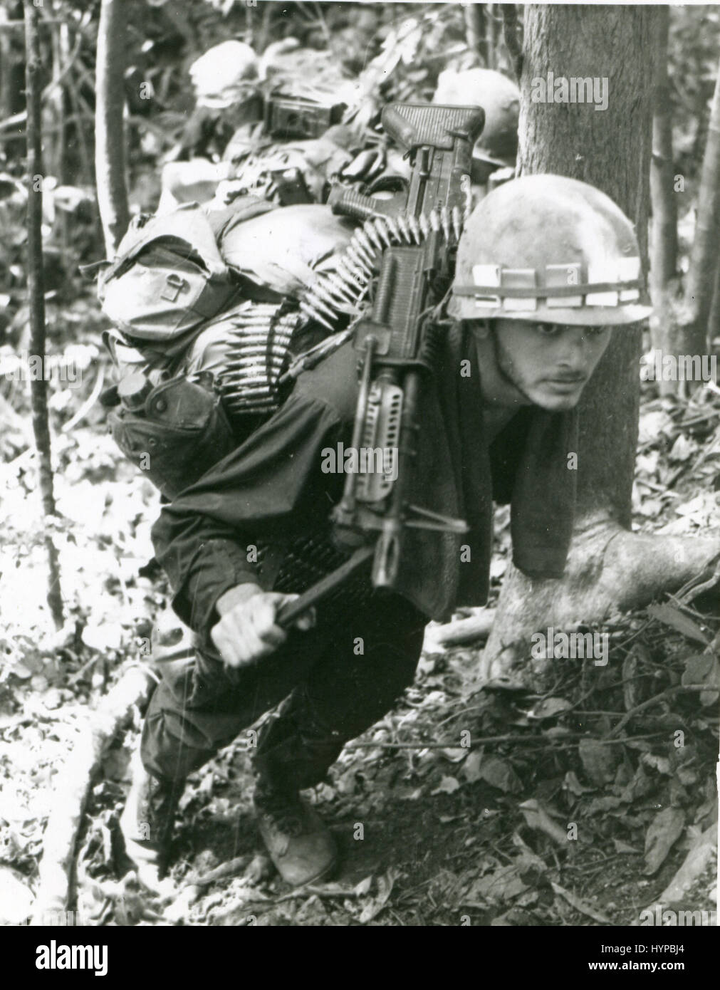 Un 8e Inf. Div machine gunner fait son chemin d'une pente raide lors d'une mission de recherche et de destruction. La mitrailleuse est un M-60. 15 mai 1969. Banque D'Images