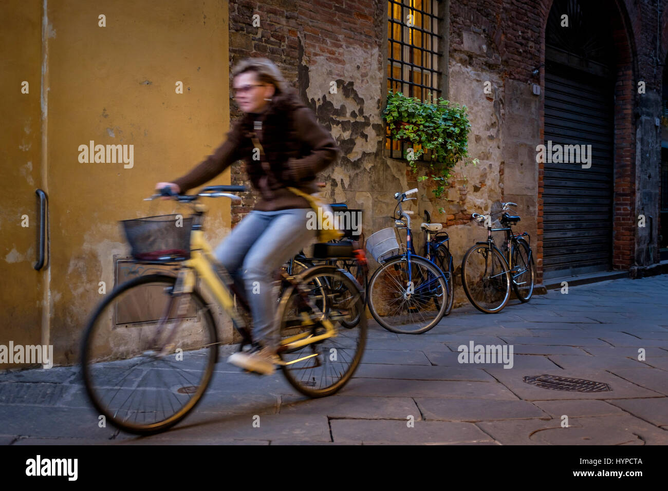 LUCCA ITALIE - CIRCA MAI 2015 : femme de rouler à vélo dans les rues de Lucca, une célèbre ville médiévale en Toscane. Banque D'Images
