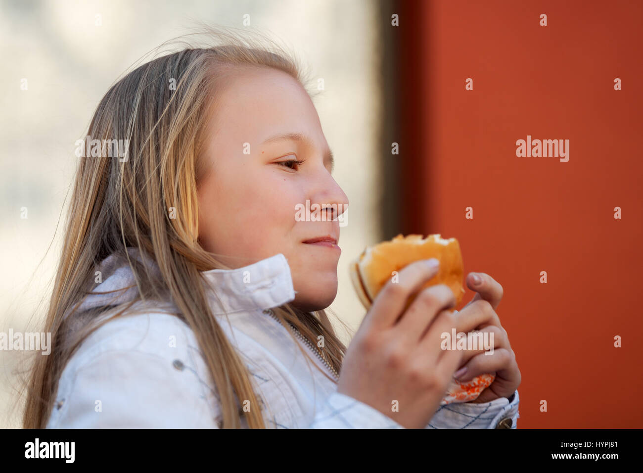 Teenage girl eating a burger Banque D'Images