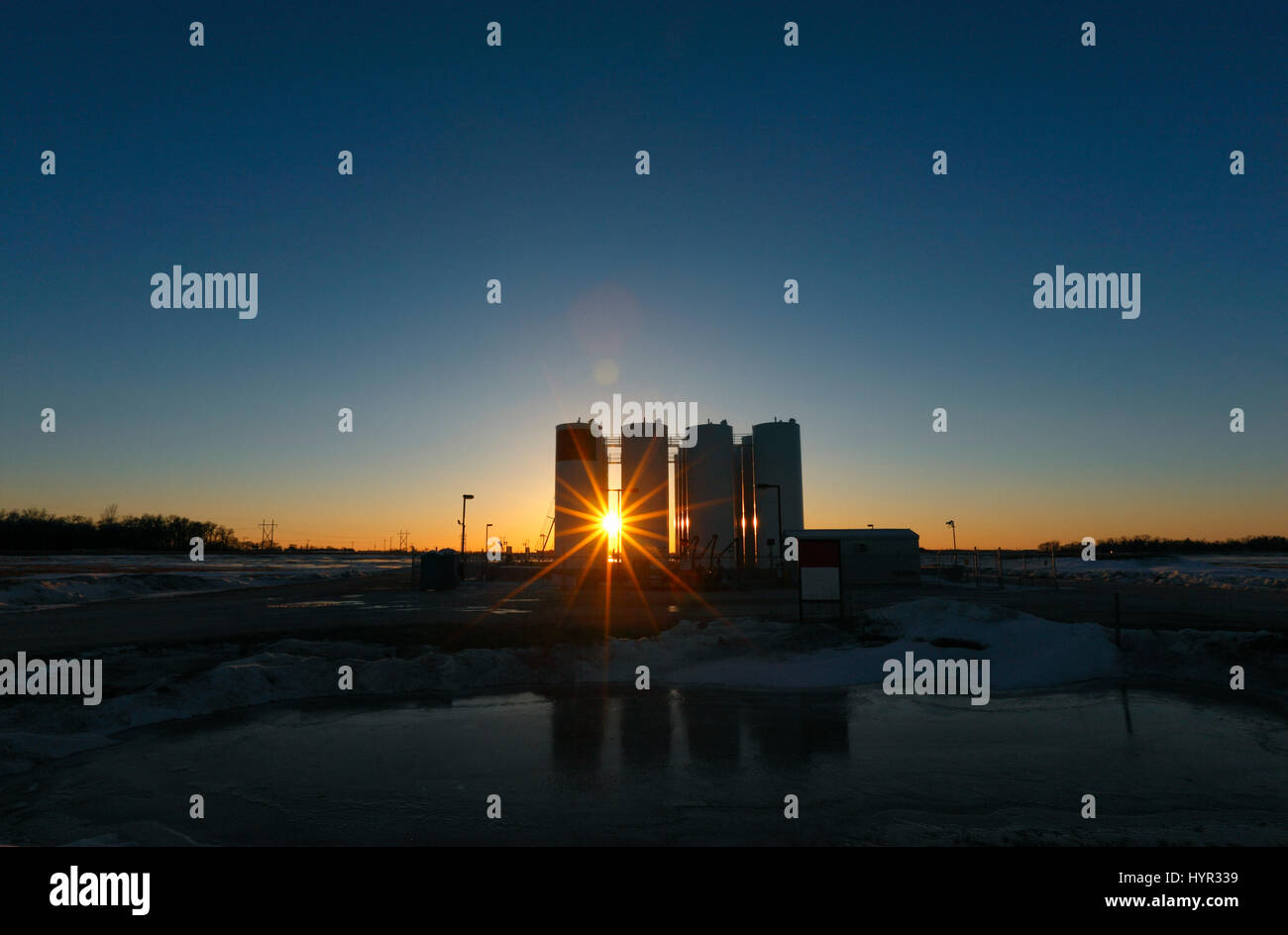 Sun star entre les conteneurs de gaz au coucher du soleil au Canada Banque D'Images