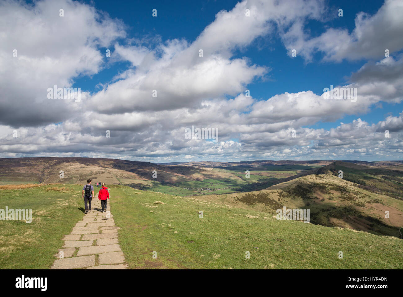 Jeune couple en train de marcher le long de la crête de Mam Tor dans le Peak District sur une journée de printemps ensoleillée. Banque D'Images