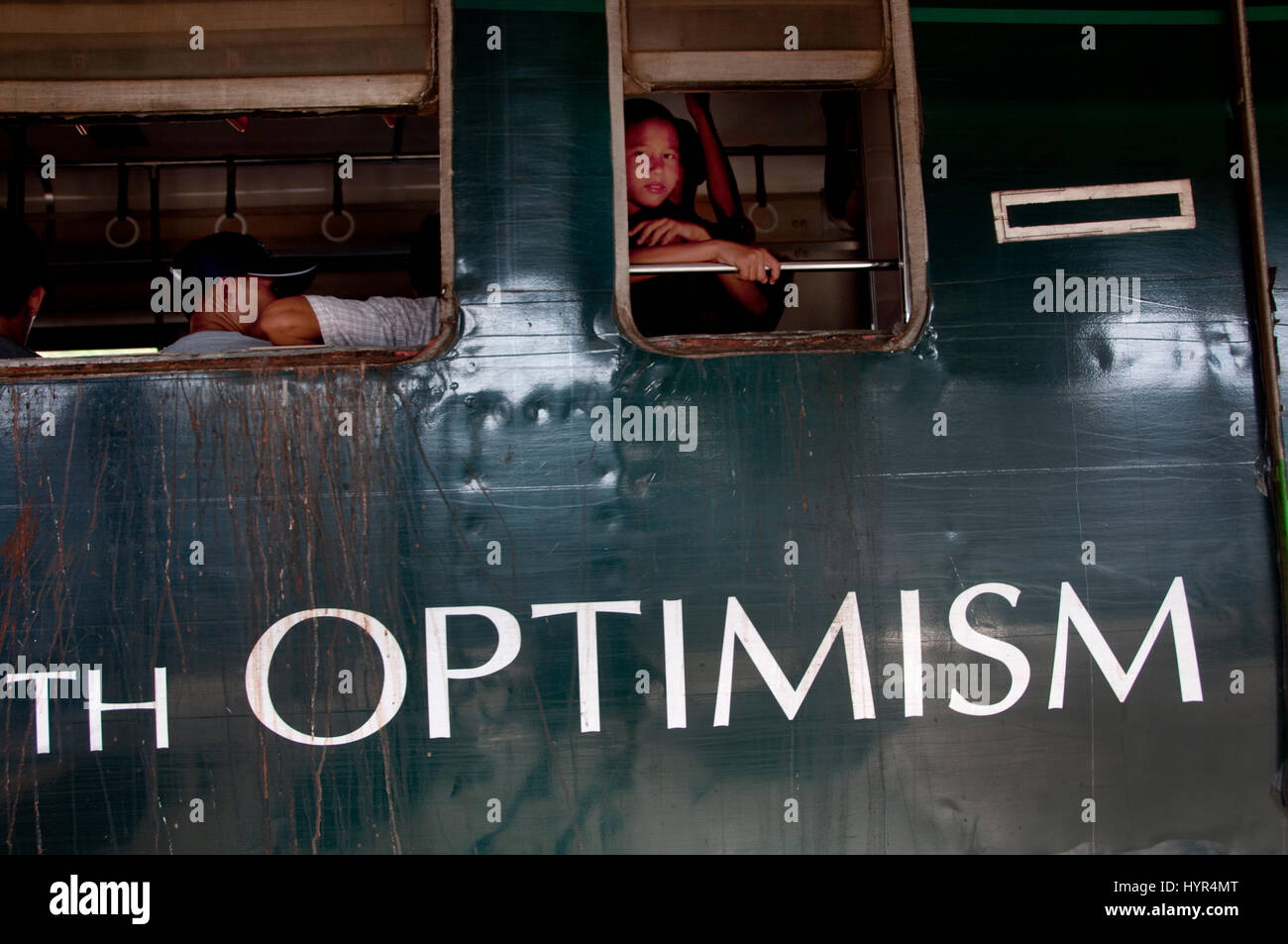 Myanmar (Birmanie). Yangon. La circulaire avec une voiture peinte avec une publicité pour la bière et le mot 'optimisme'. Banque D'Images