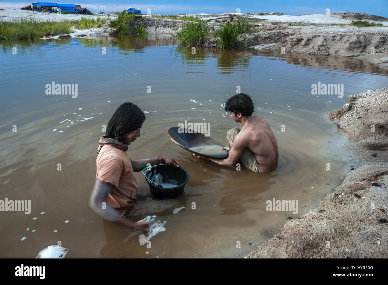 Deux mineurs orpaillage sur un étang dans Galangan Kereng Pangi en mine d'or, Kalimantan, Indonésie. Banque D'Images