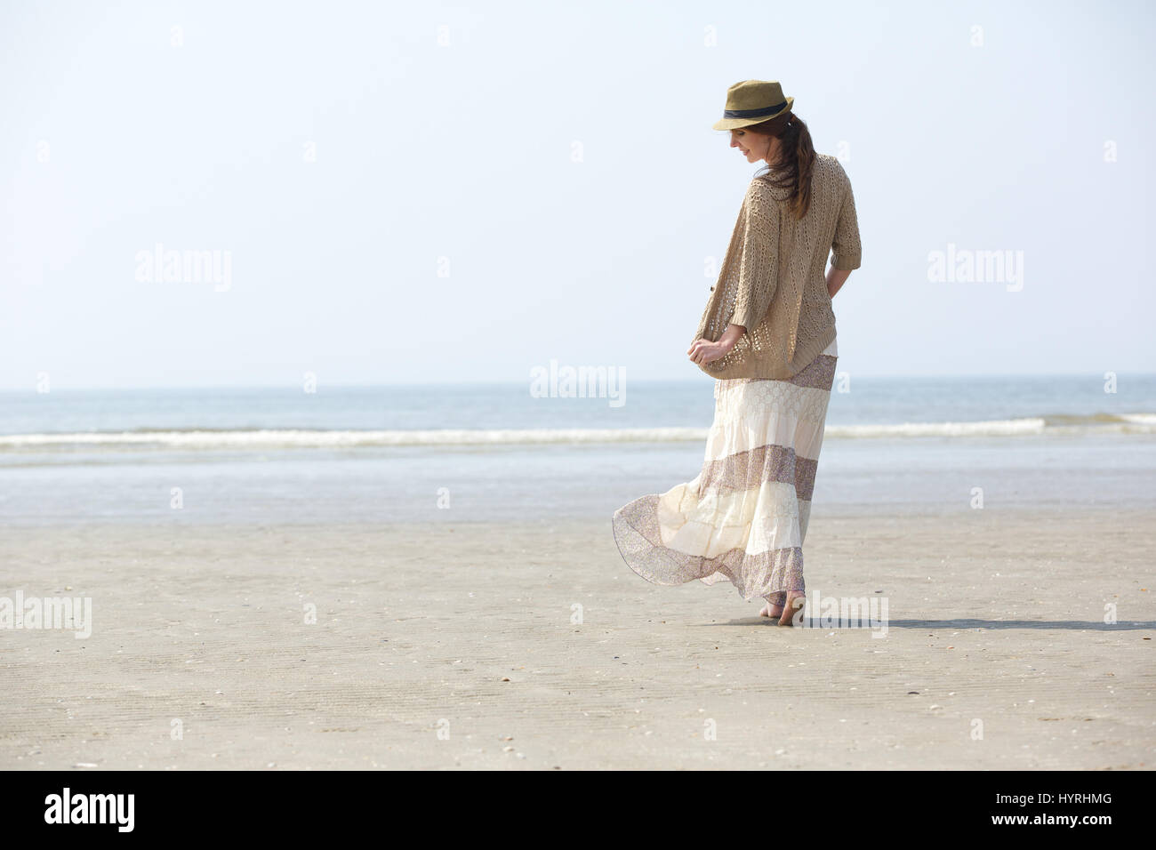 Vue arrière portrait d'une belle femme marchant sur la plage Banque D'Images