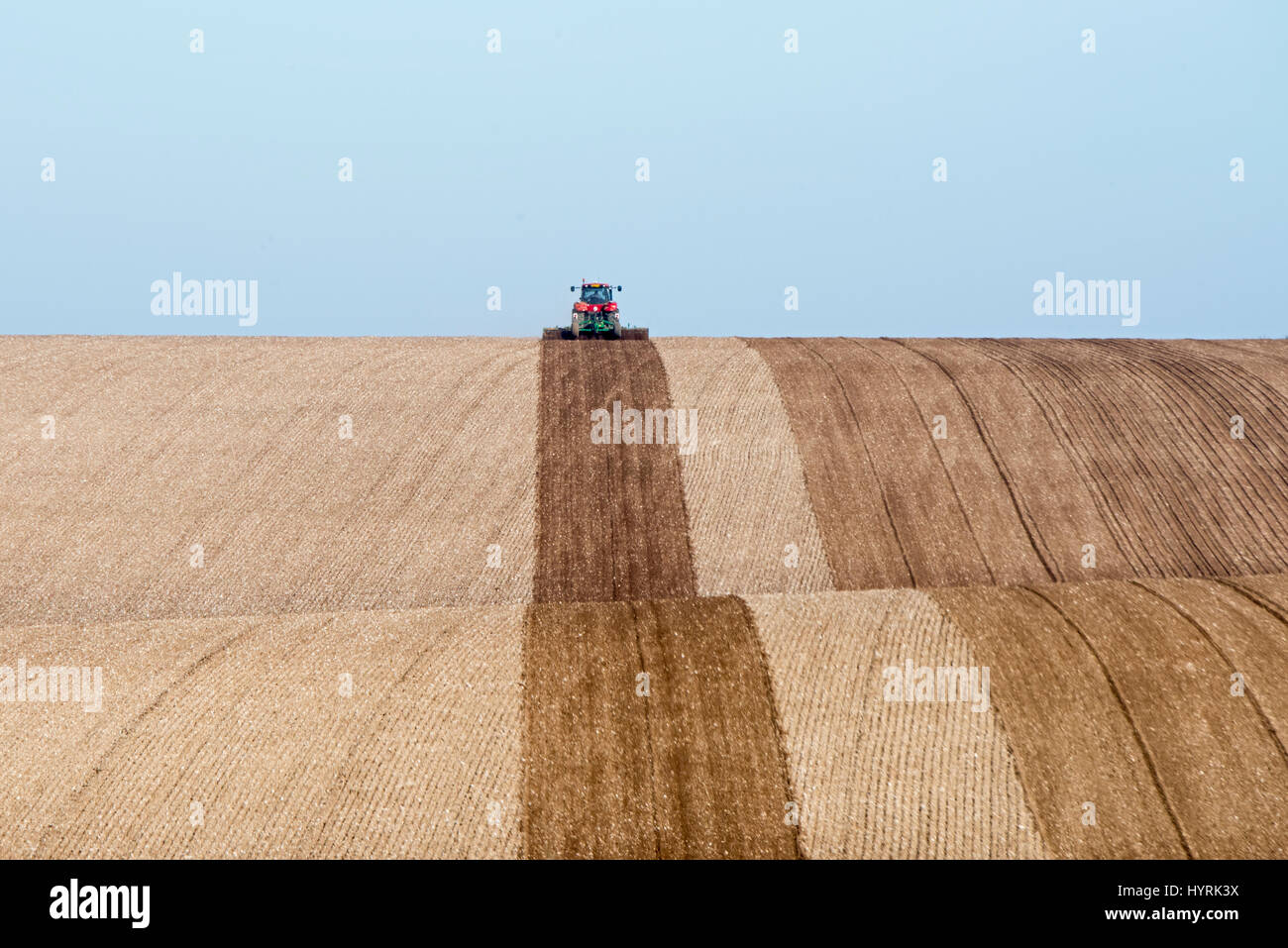 Le tracteur laboure terres agricoles vallonnées d' près de North Norfolk Mars Banque D'Images